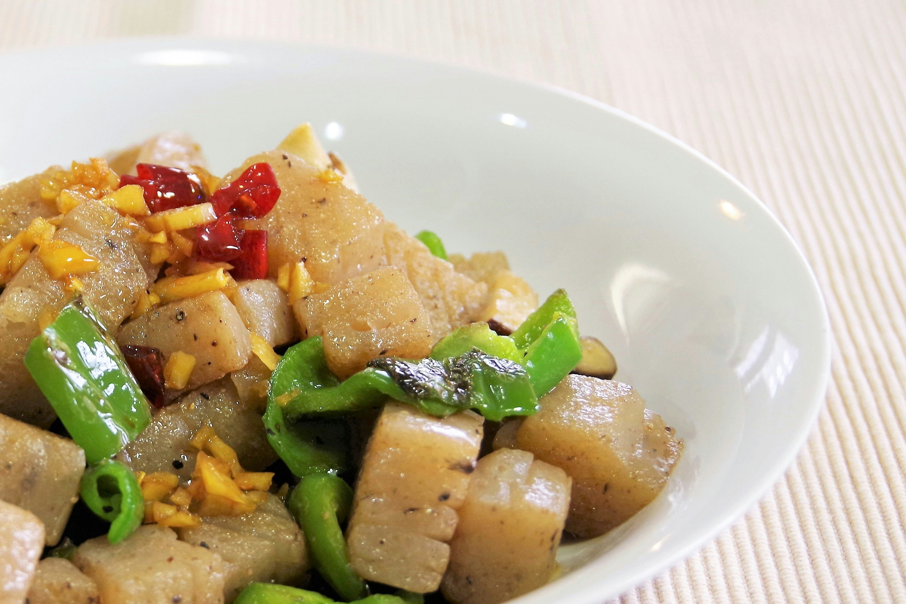 白盤裡盛著的雞肉蔬菜丁炒菜