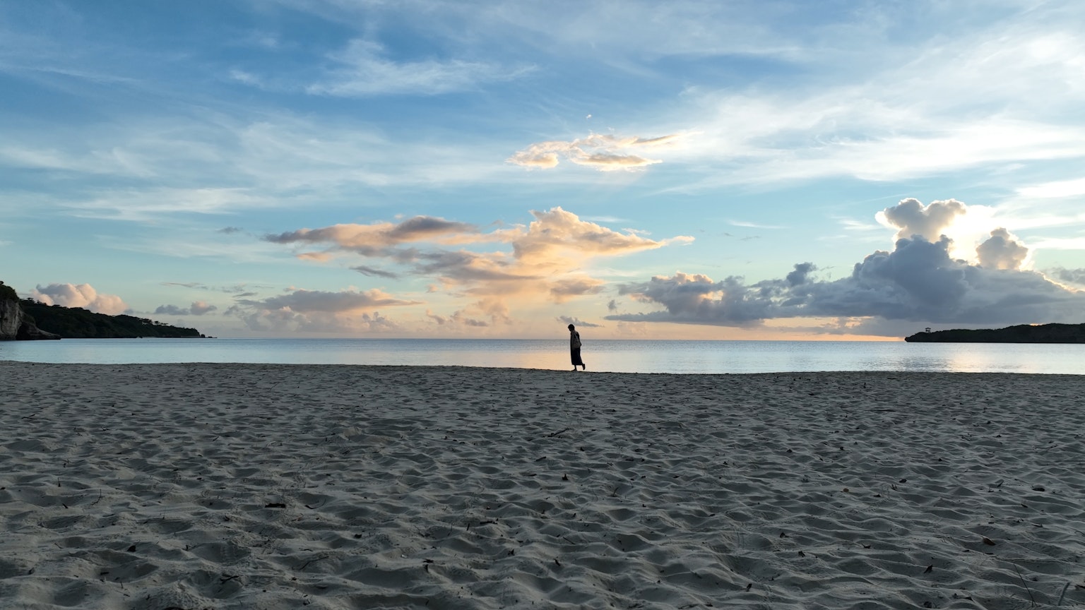 Persona haciendo una pose en una playa serena con una hermosa puesta de sol