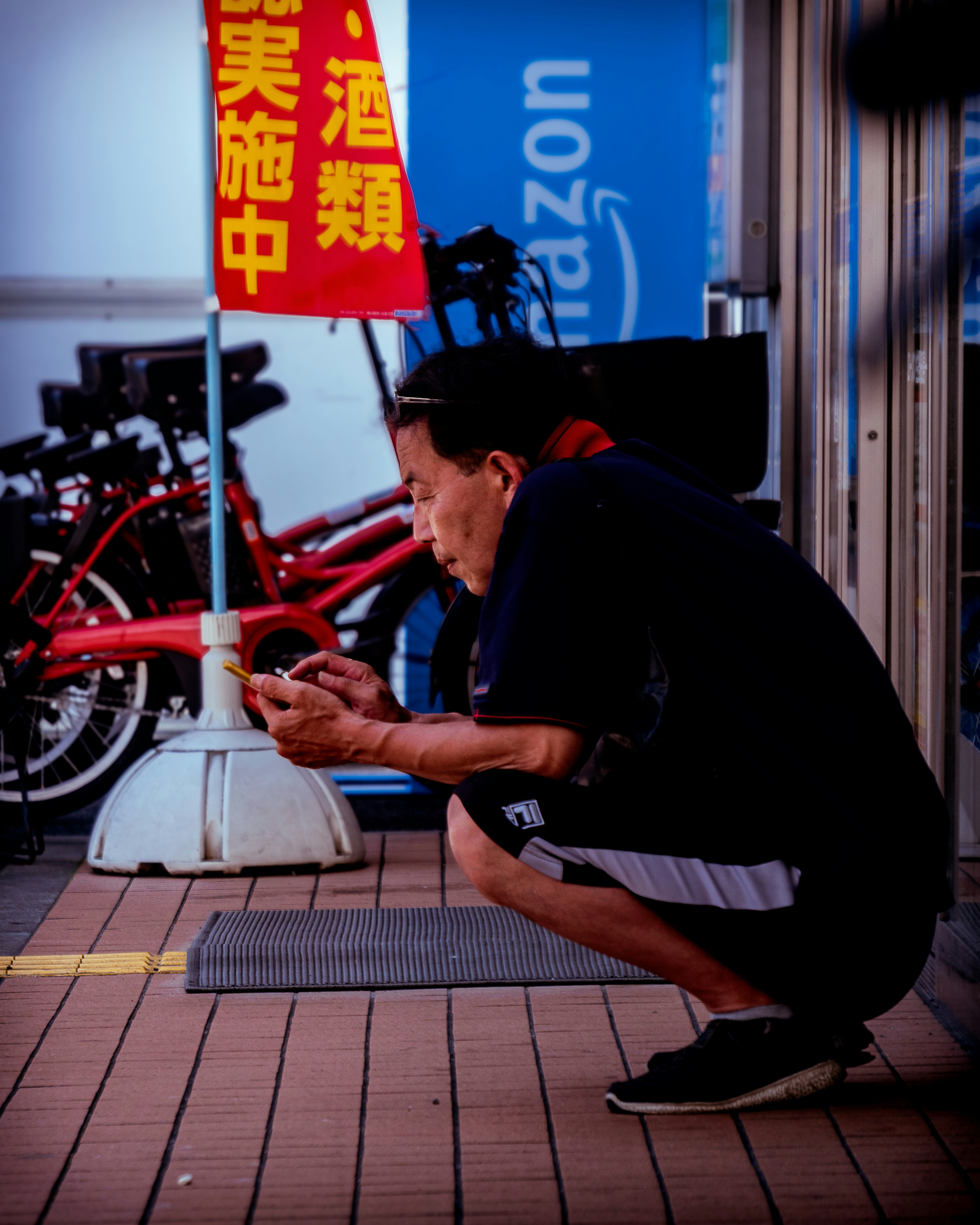 man working by bicycles along a narrow storefront alley