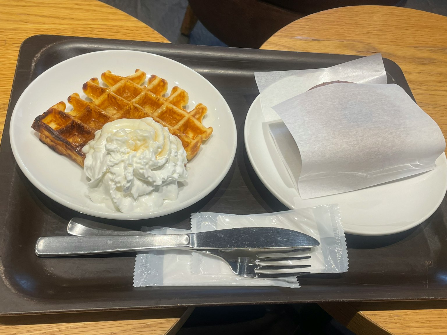Plate of waffles with whipped cream on the side