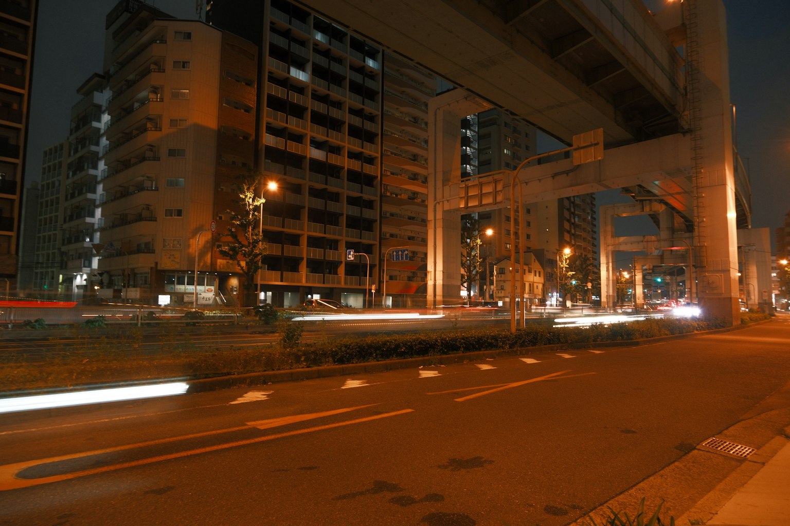 Paysage urbain nocturne avec des bâtiments sous une autoroute surélevée traînées lumineuses de voitures passantes