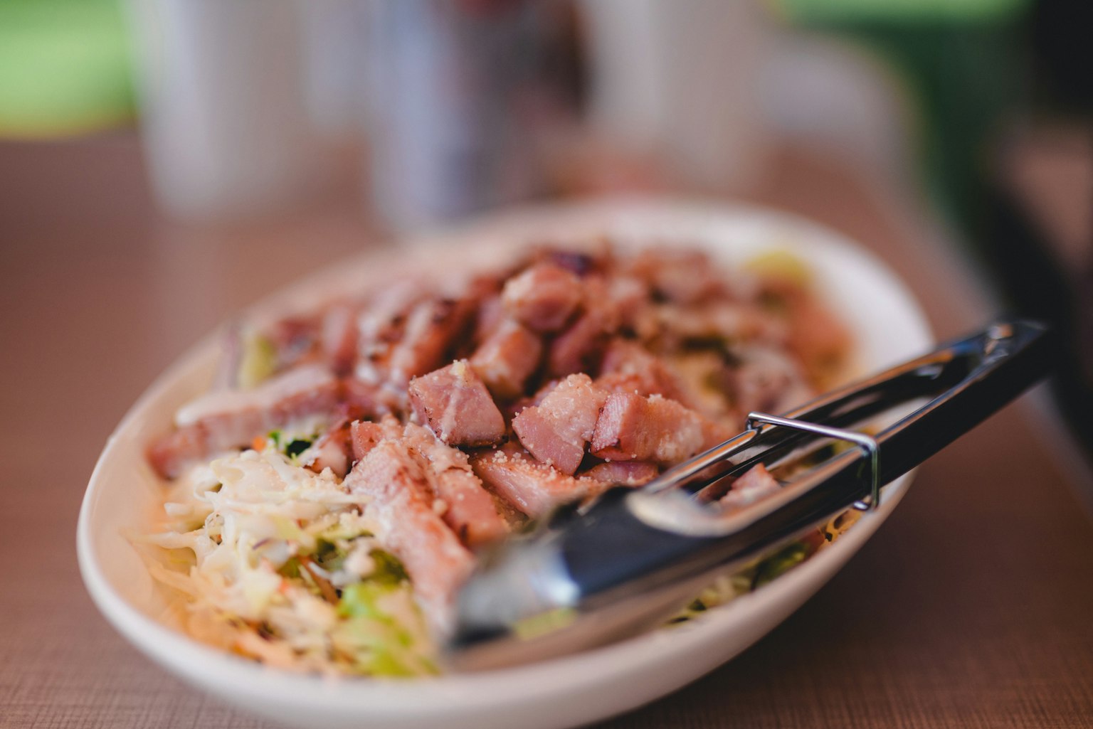 Dish featuring shredded cabbage topped with grilled meat