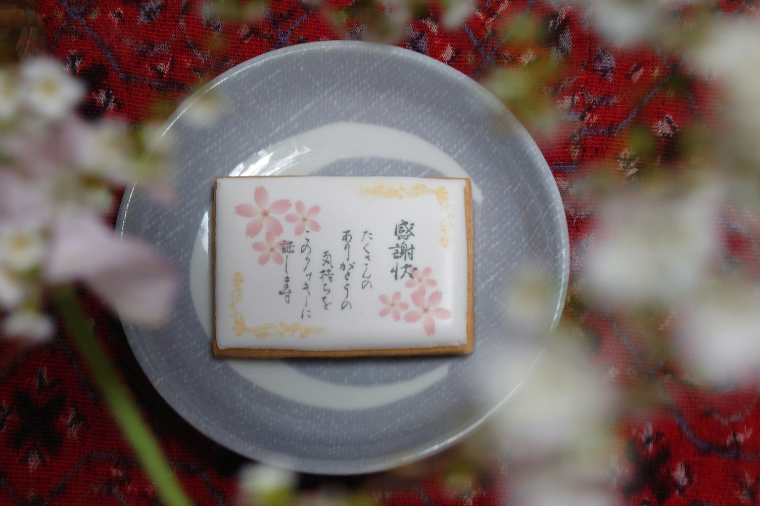 白盤上的日本糖果，背景是櫻花