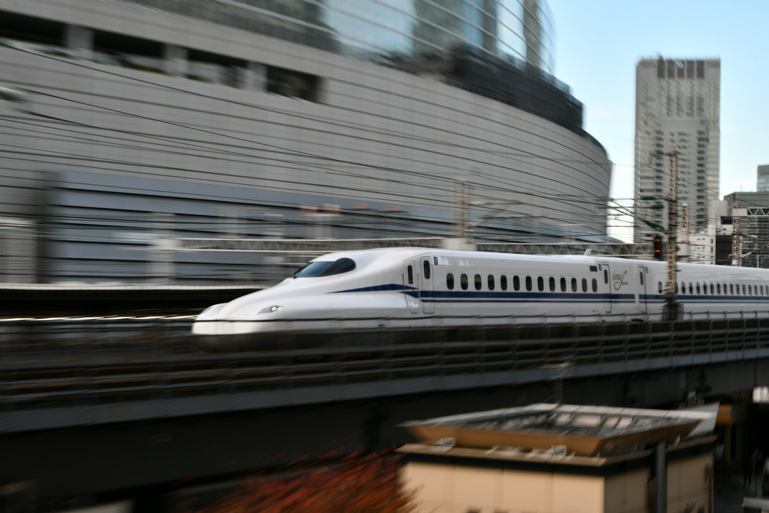 Shinkansen, der schnell an einer modernen Stadtsilhouette vorbeifährt
