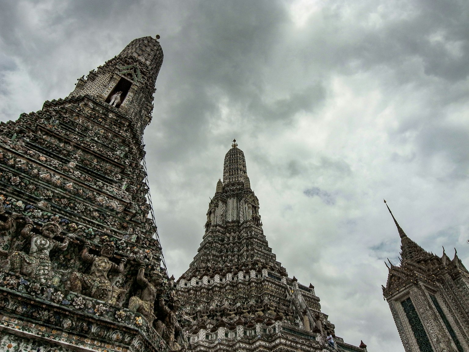 Hohe Türme des Wat Arun vor einem bewölkten Himmel