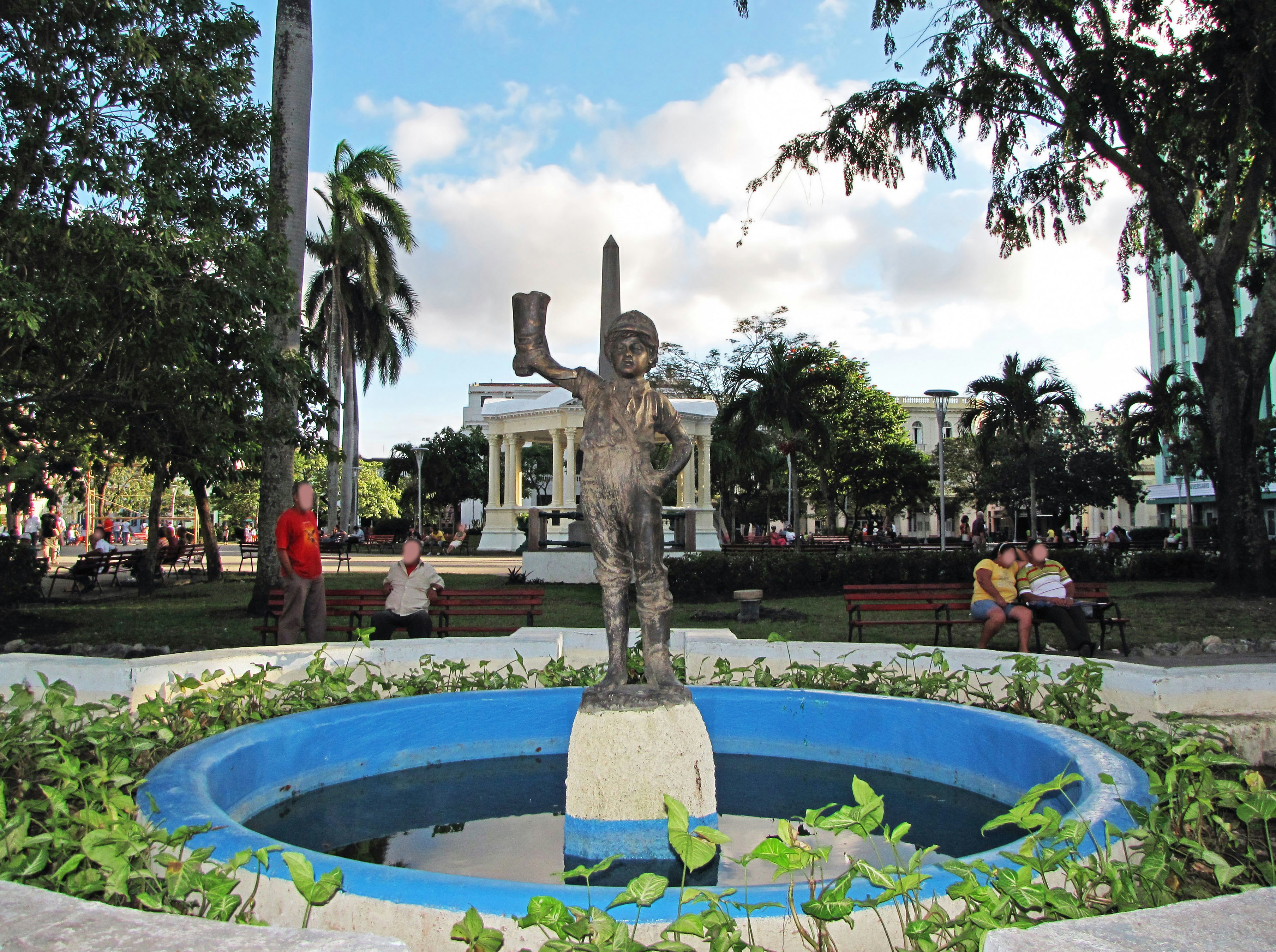 piazza verde in un parco con fontana e statua scolpita
