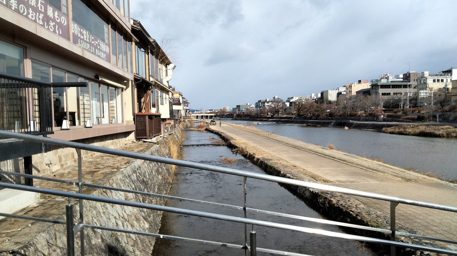 Scenic view of a riverbank pathway with buildings
