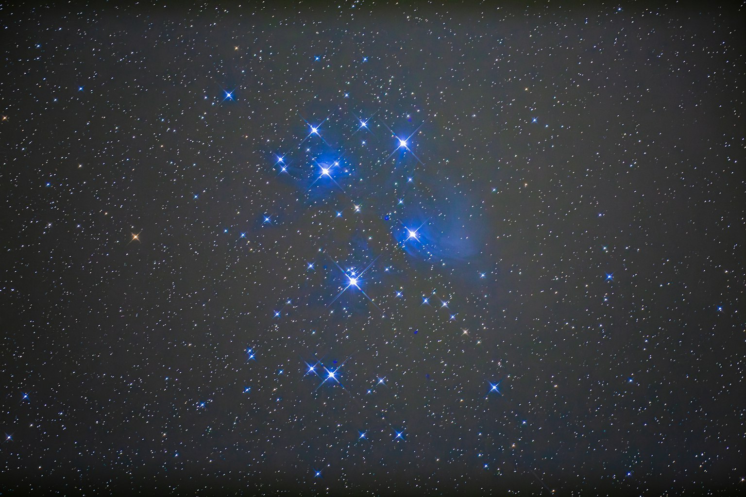 Grappe d'étoiles bleues brillantes dans le ciel nocturne avec nébuleuse