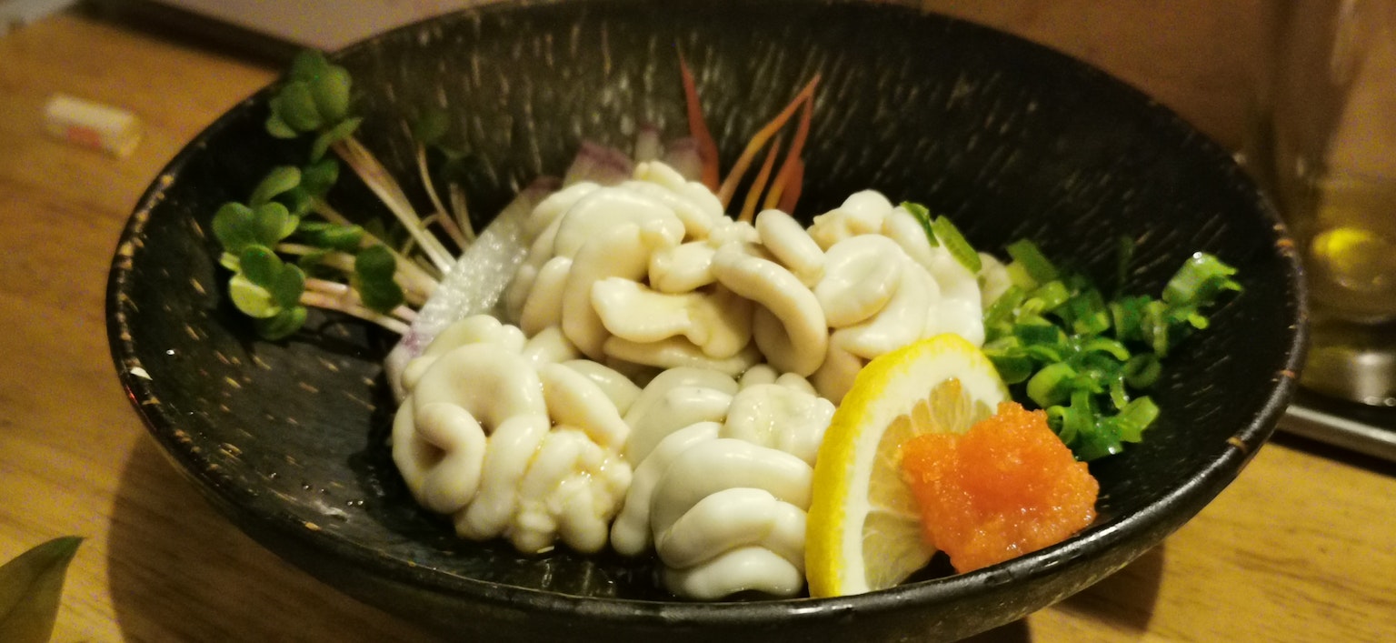 Plato de mariscos frescos con texturas únicas y guarnición de limón y naranja