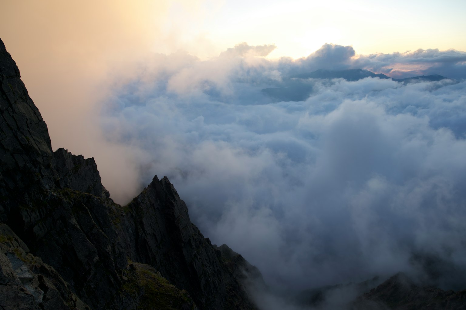 Nuvole che coprono un paesaggio montano al tramonto