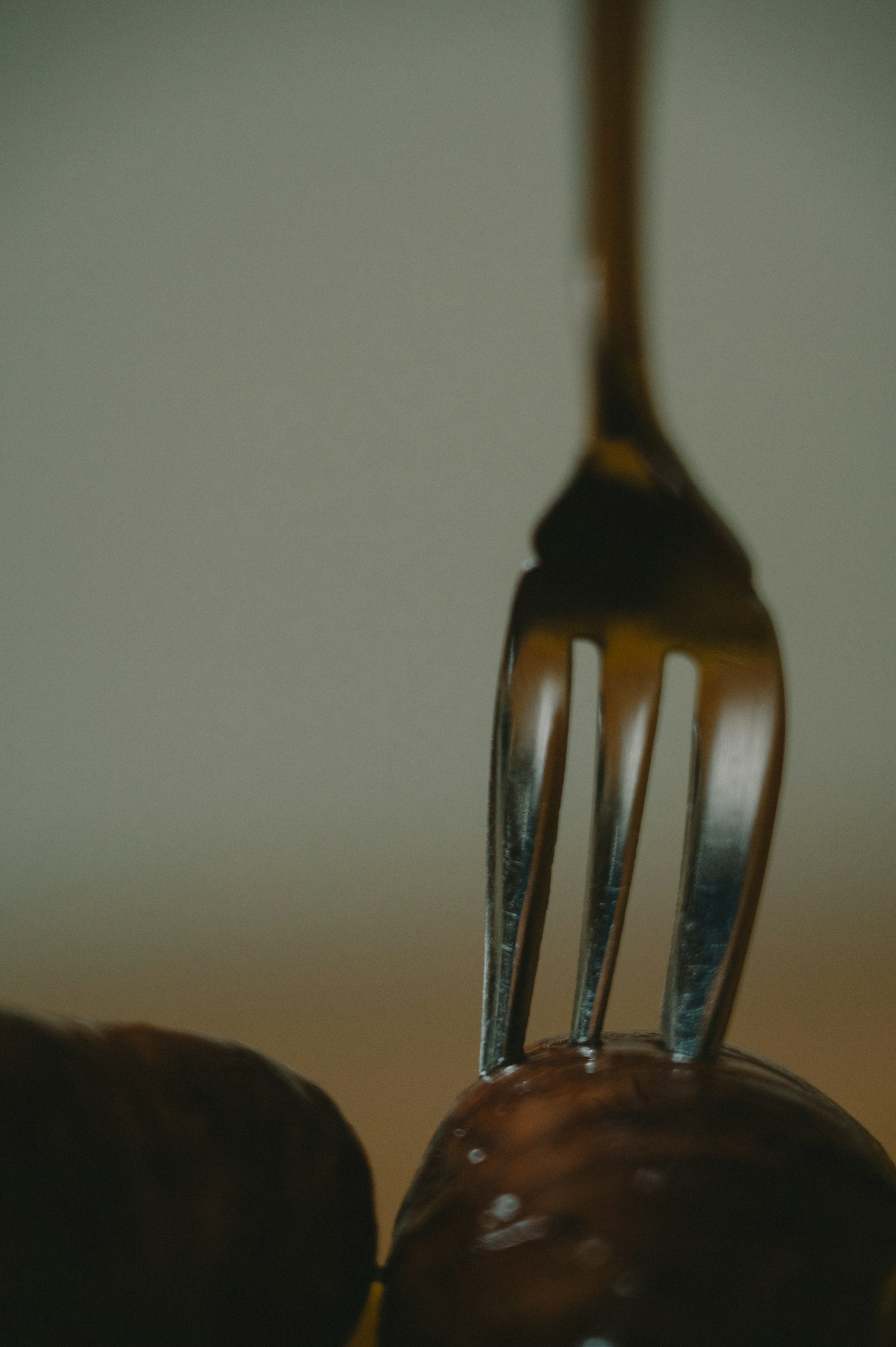 Gros plan d'une fourchette perçant une boule en chocolat
