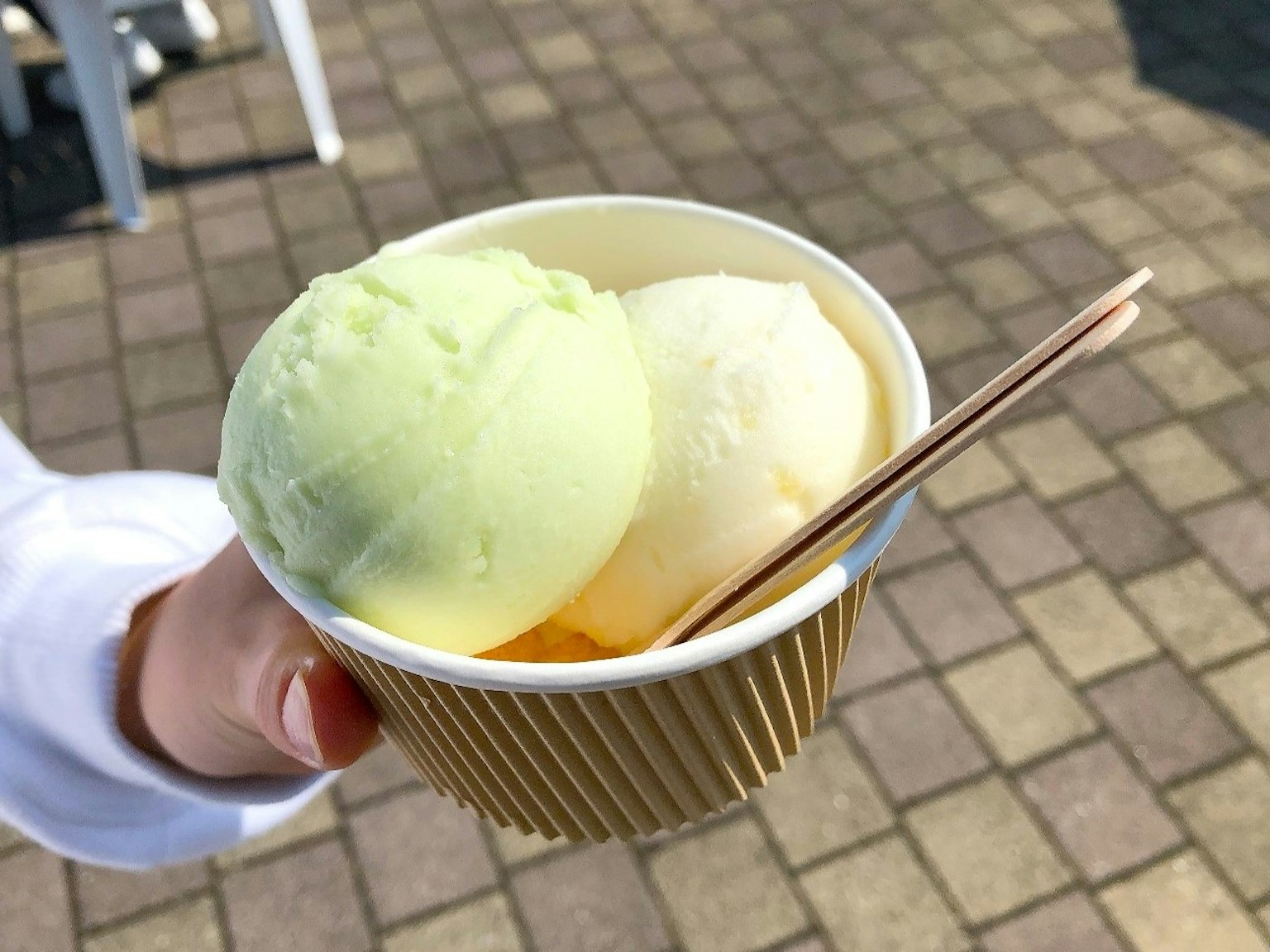 一只手握着一杯绿色和白色的冰淇淋
