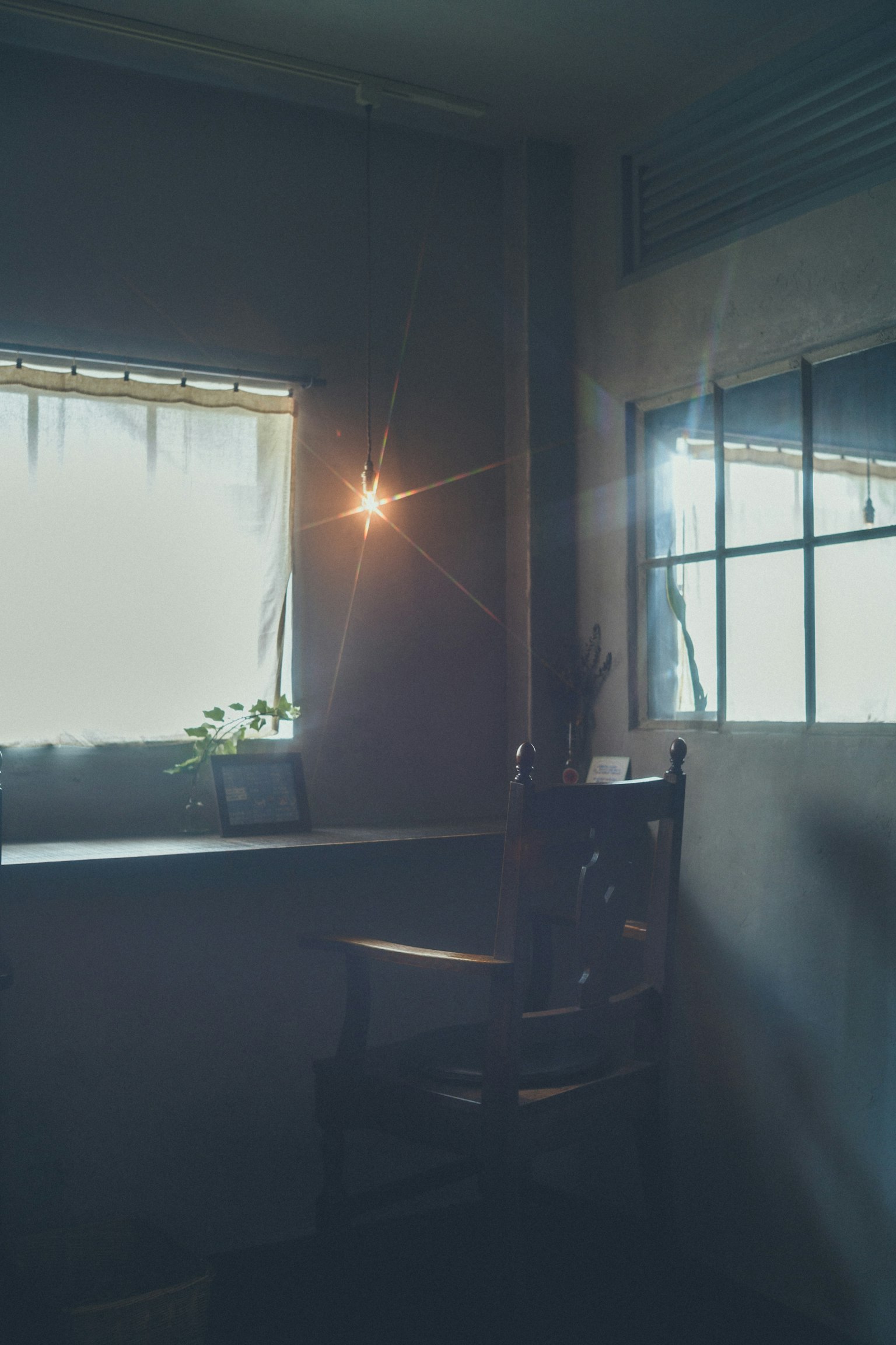 Holzstuhl in einem schwach beleuchteten Raum mit sanftem Licht vom Fenster