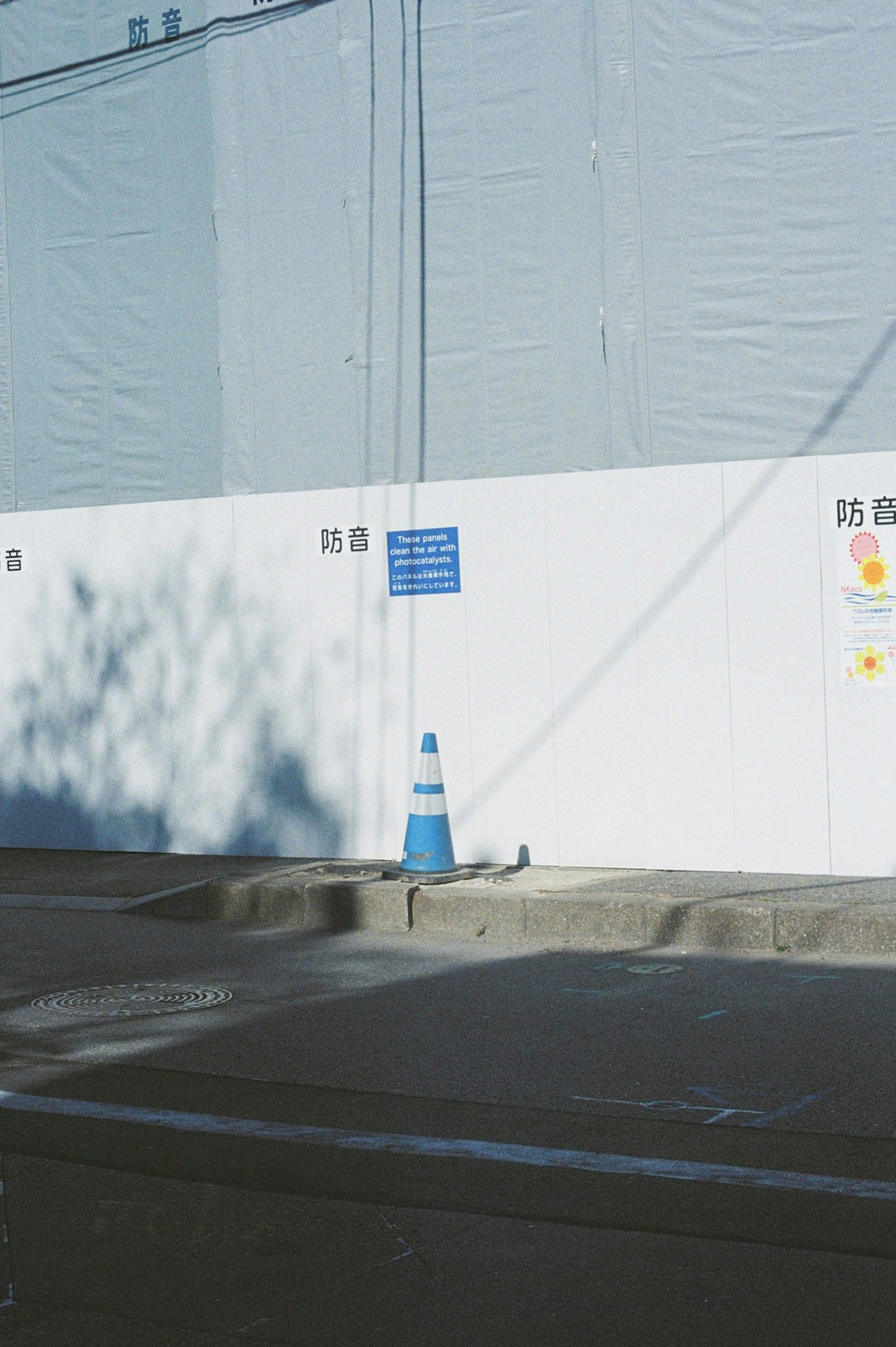 Cantiere con muro bianco e cono stradale blu