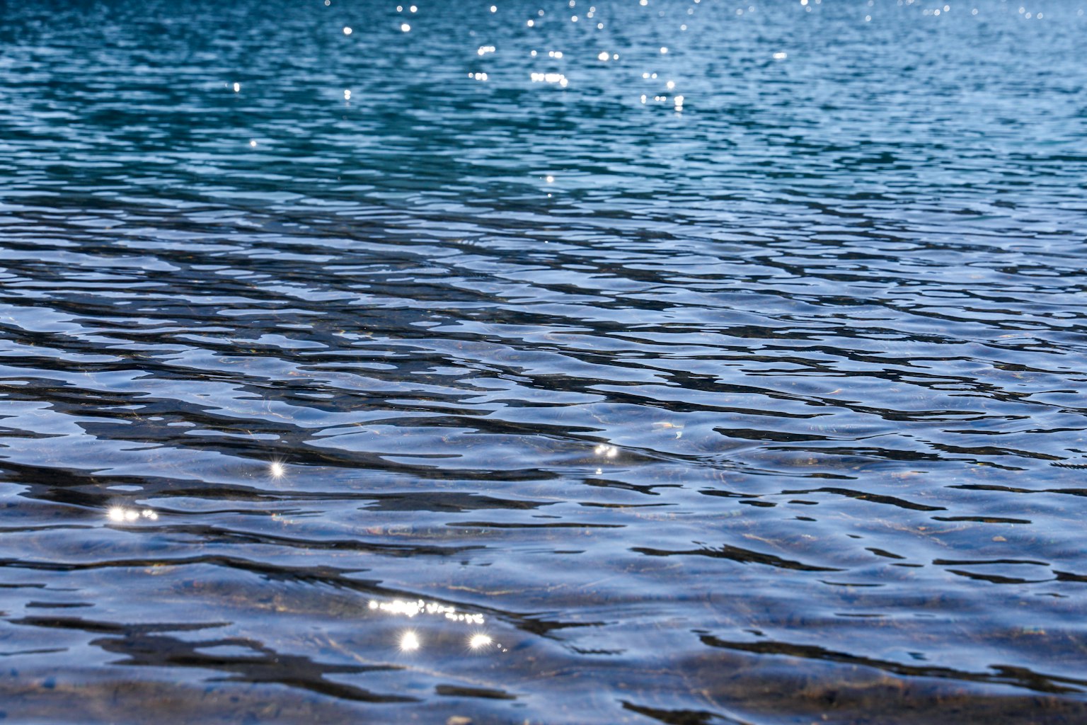 Surface d'eau ondulante avec des reflets scintillants dans une mer bleue