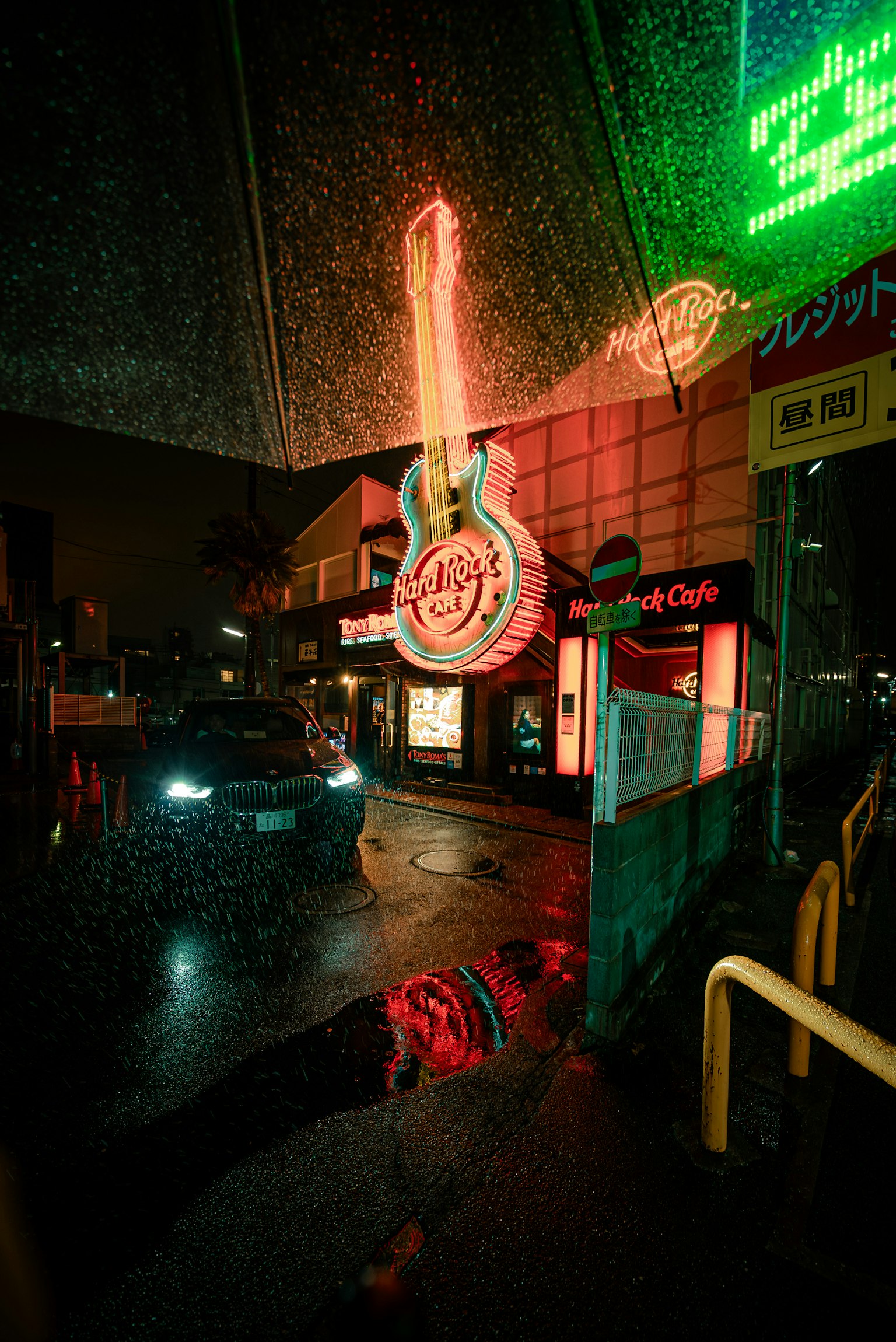Paysage urbain nocturne avec une enseigne au néon en forme de guitare sous la pluie