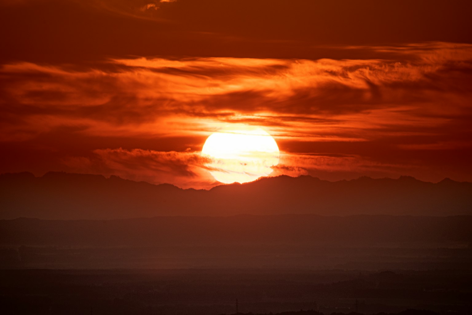 Sunset behind mountains with a vibrant red sky