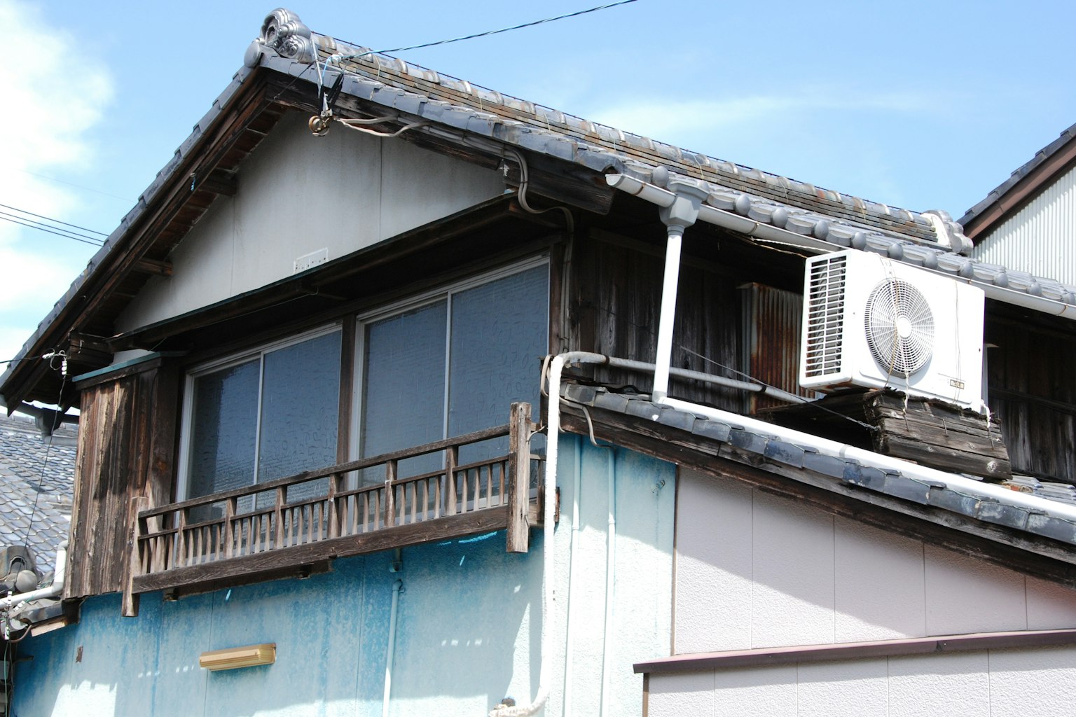 老舊日本房屋外觀，木質陽台和空調單元