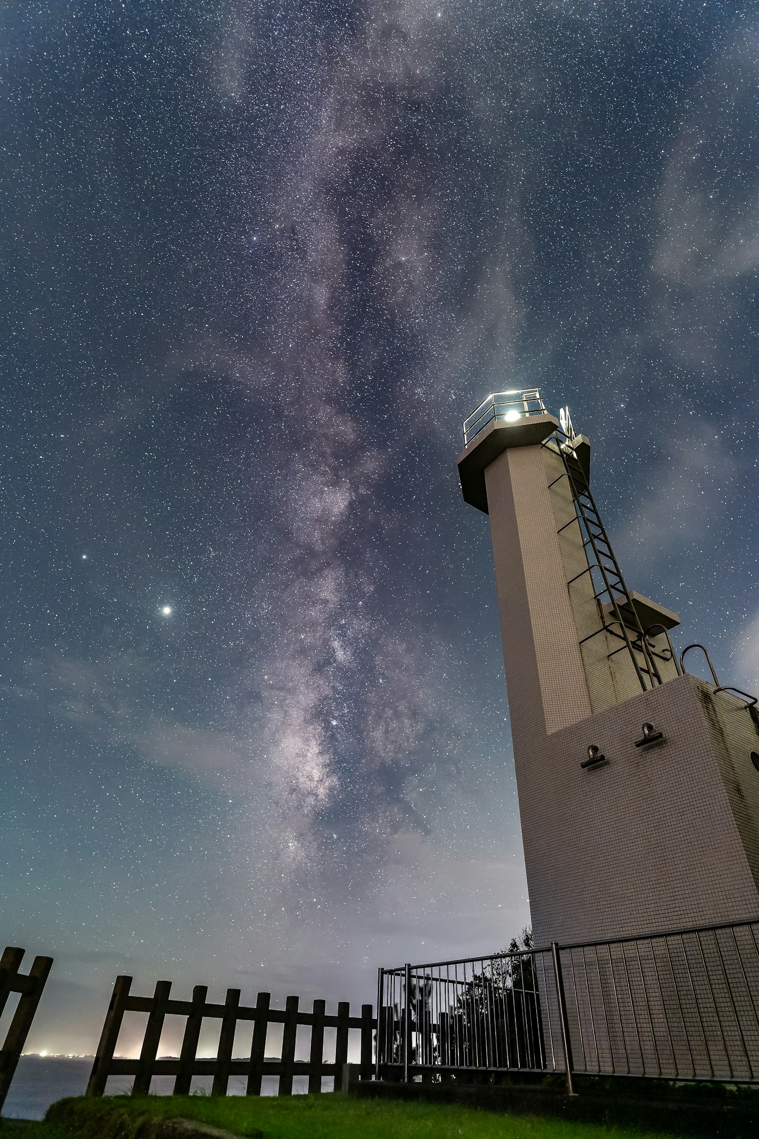 Faro sotto un bellissimo cielo stellato con la Via Lattea