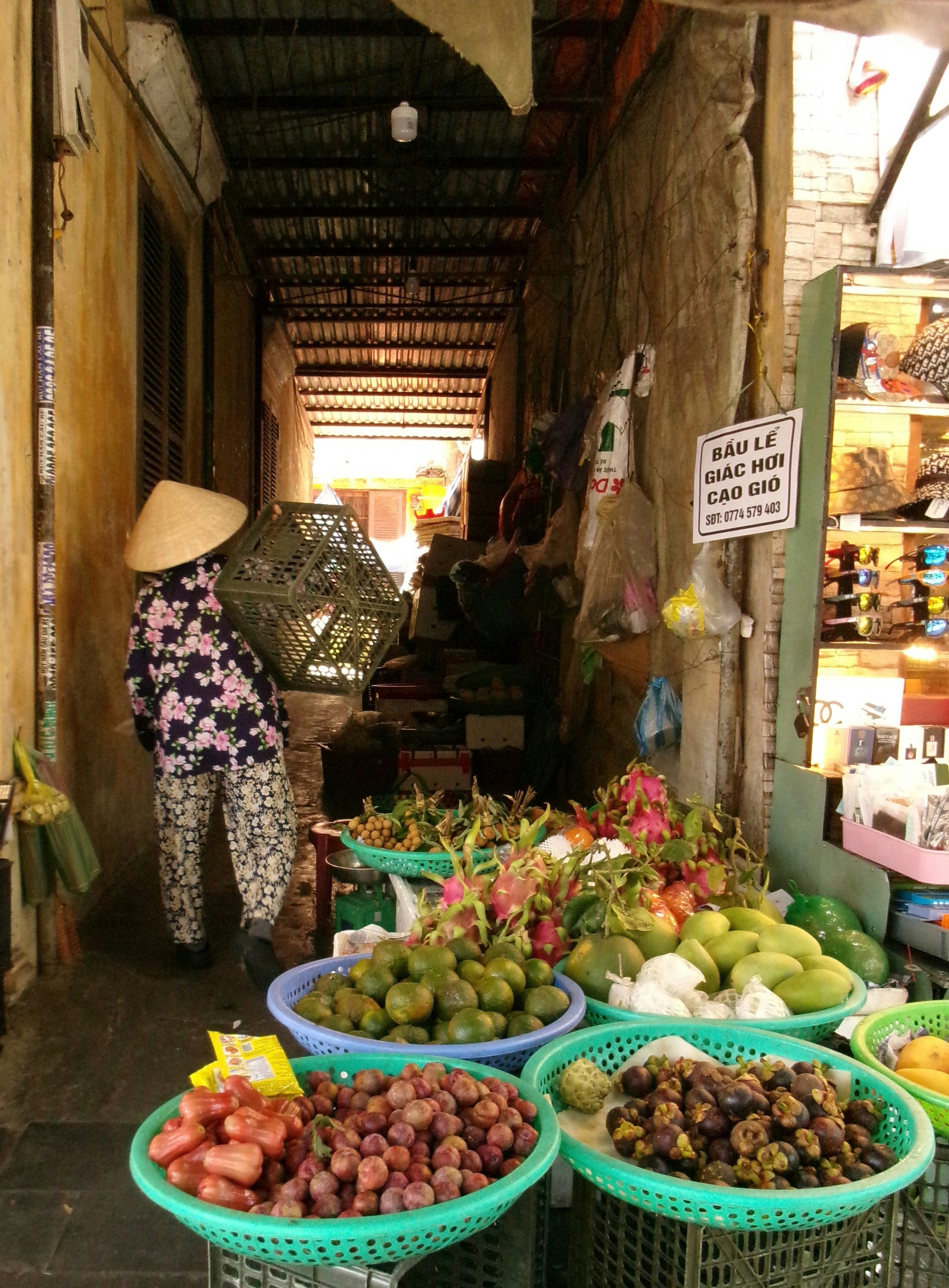 ベトナムの路地で並ぶ果物の屋台と店先