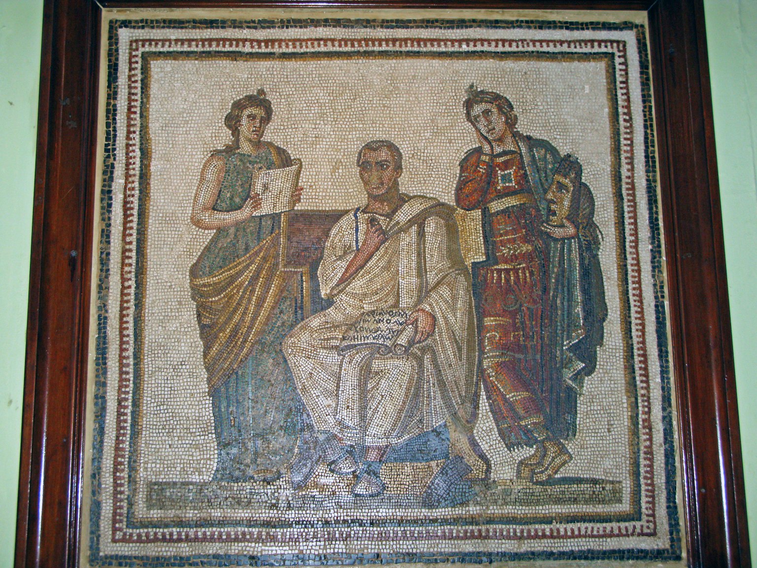 Ancient mosaic art featuring two women in robes surrounding a seated man