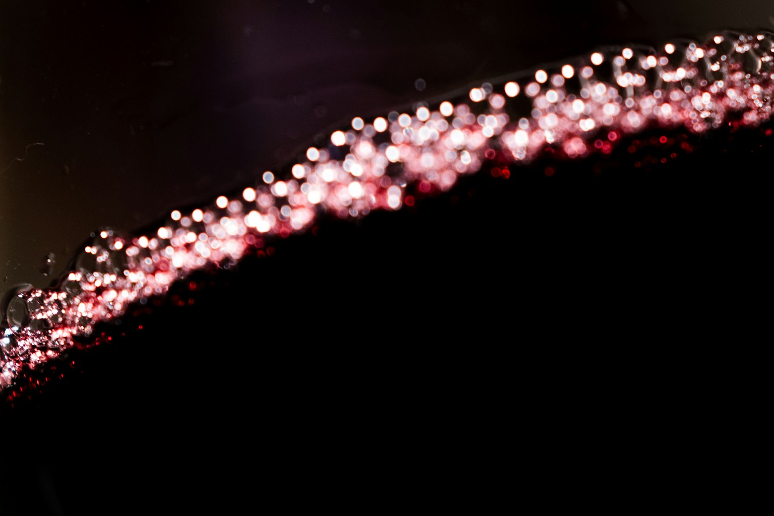 Close-up highlighting the bubbles and color of red wine