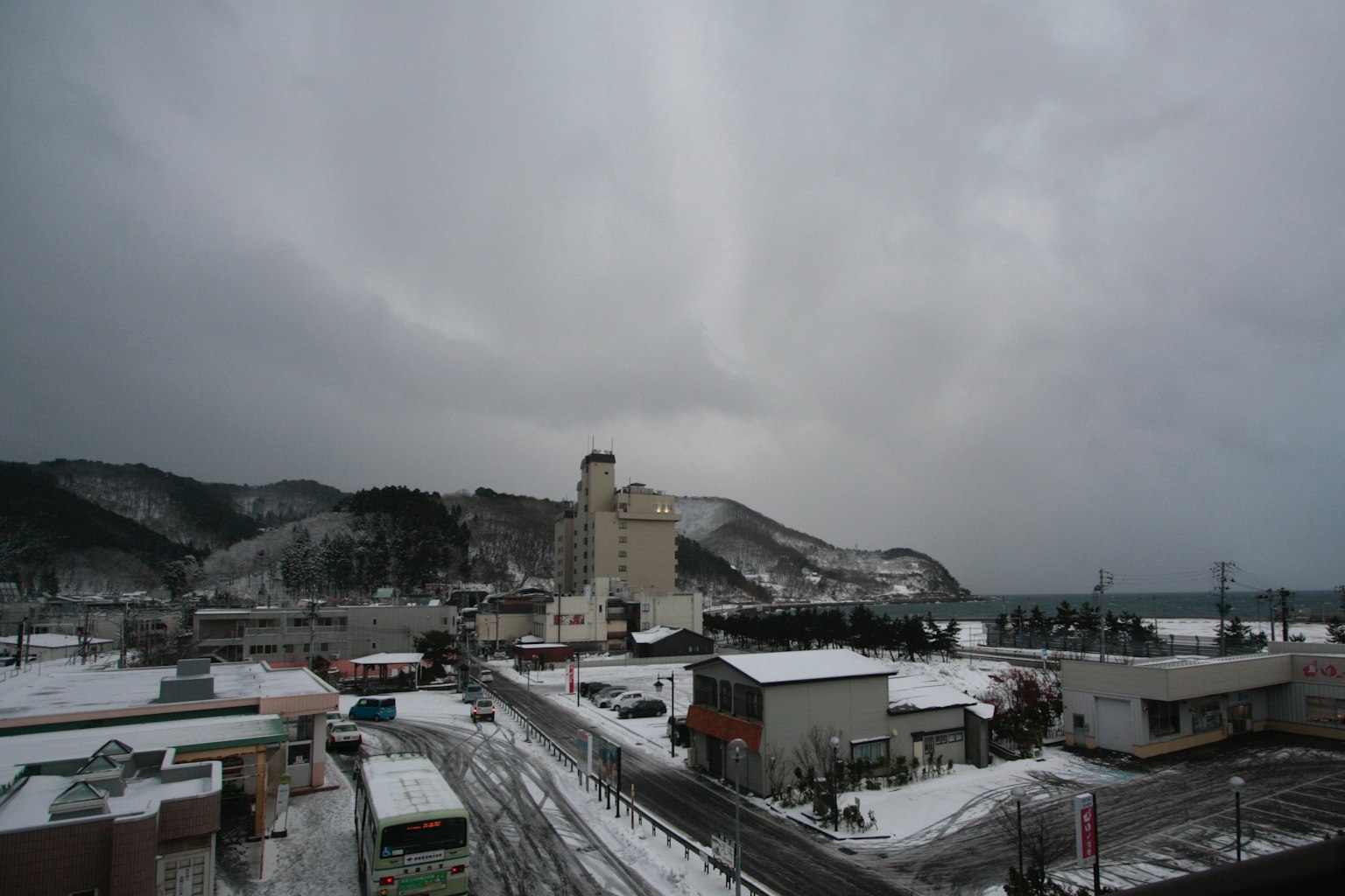 Paisaje invernal con una ciudad cubierta de nieve y montañas