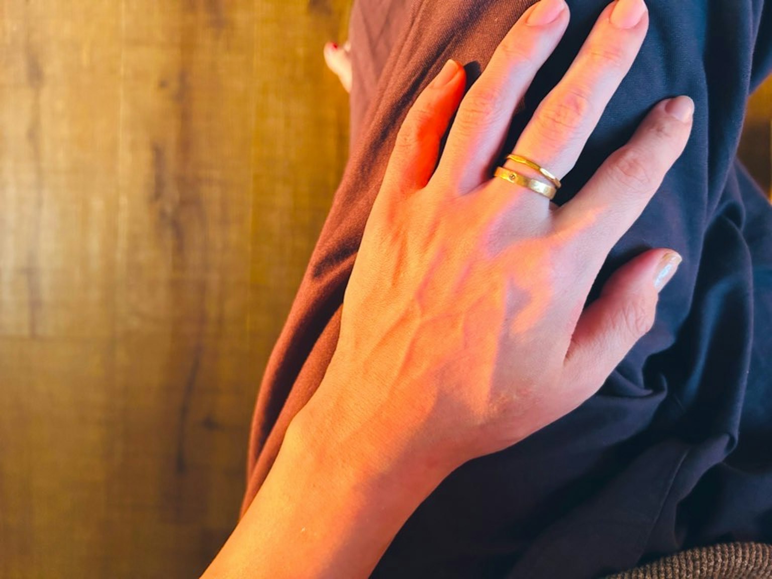 Une main reposant sur un genou avec une bague aux doigts
