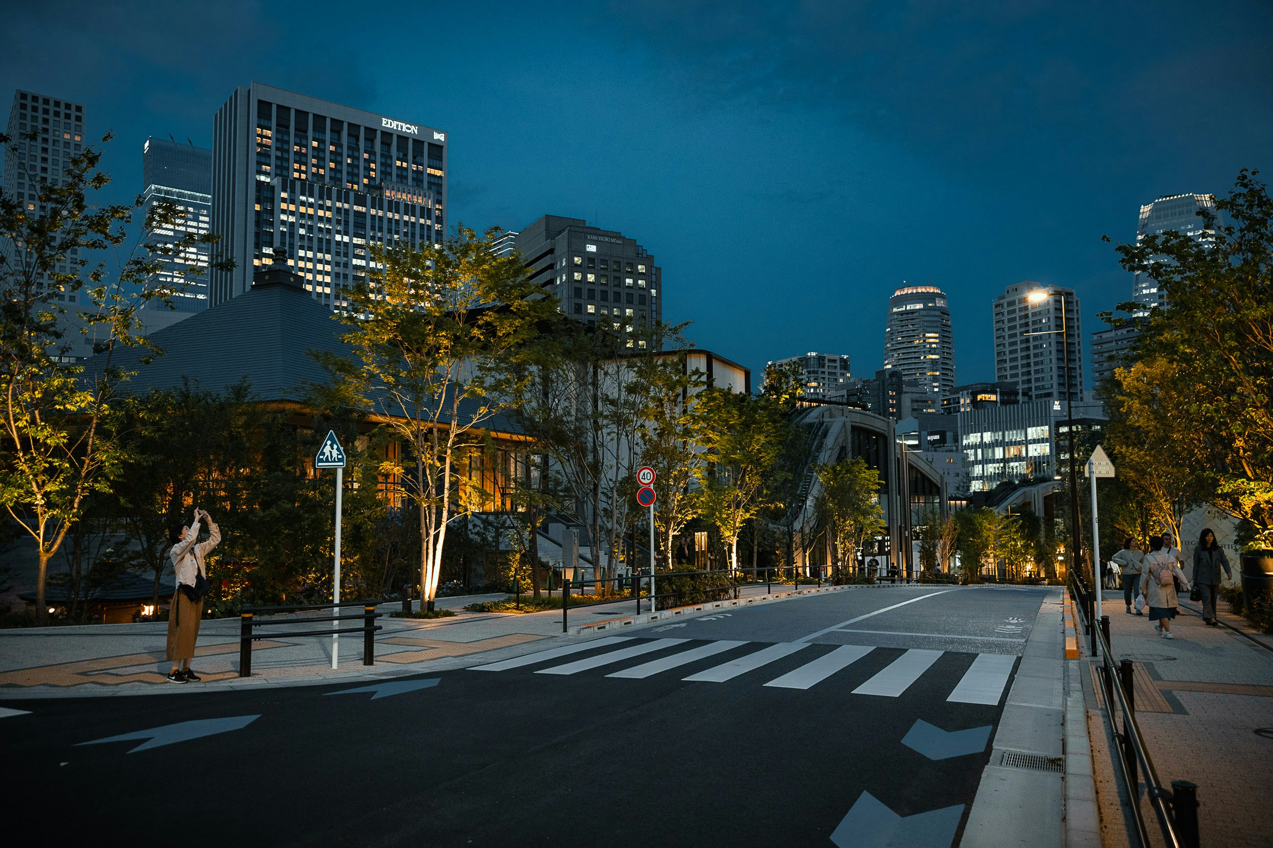 夕暮れの街路と高層ビルが並ぶ横断歩道のある風景