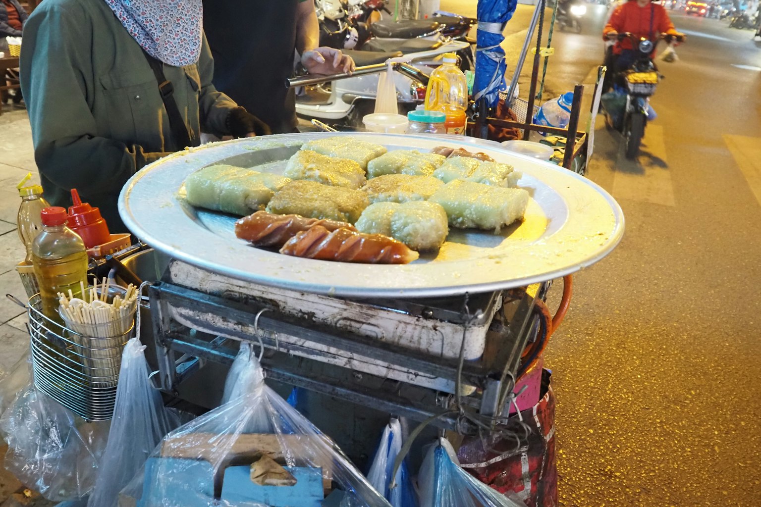 Pedagang makanan jalanan menampilkan piring besar camilan berwarna-warni