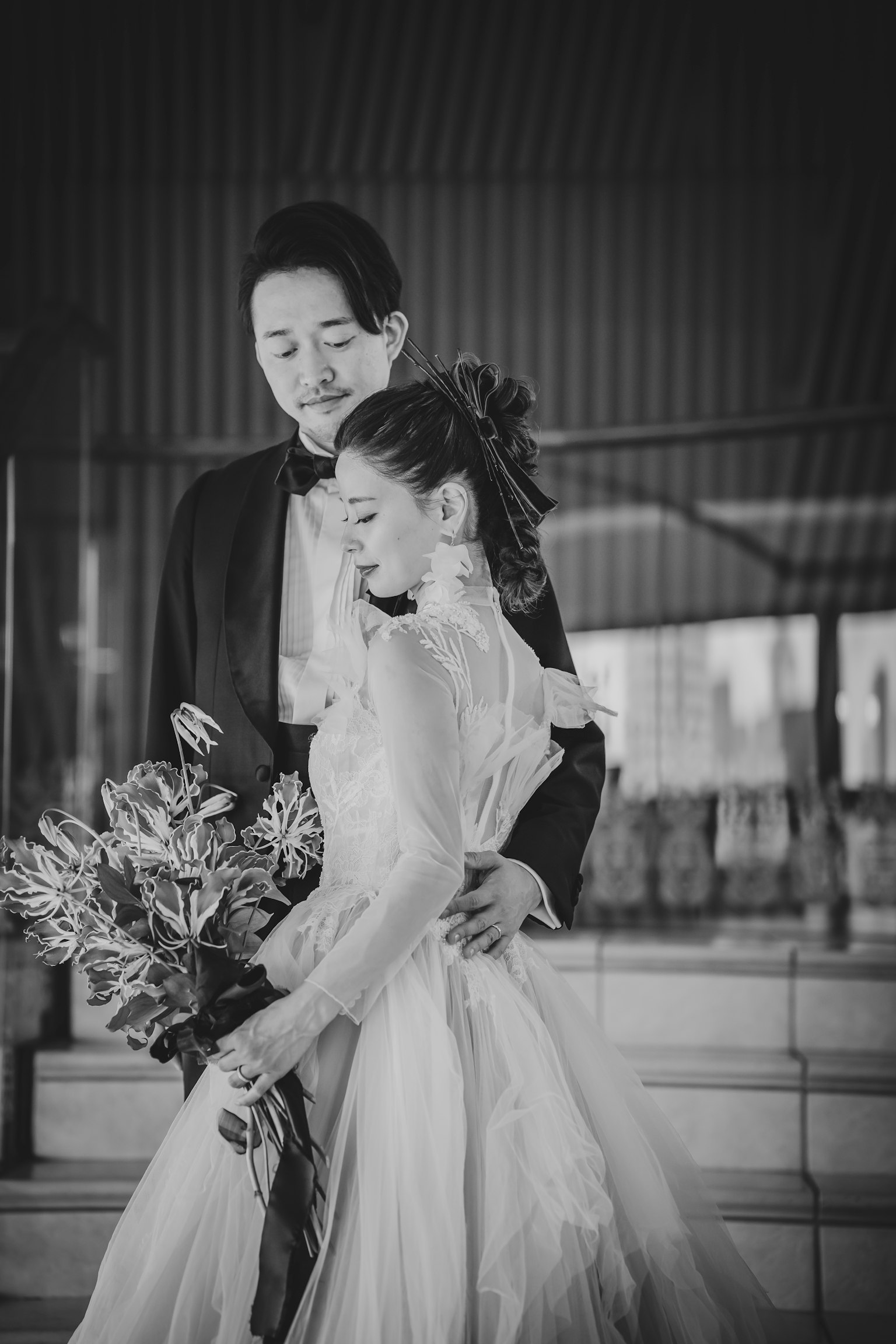 黑白婚礼照片，手持花束的新娘与拥抱她的新郎