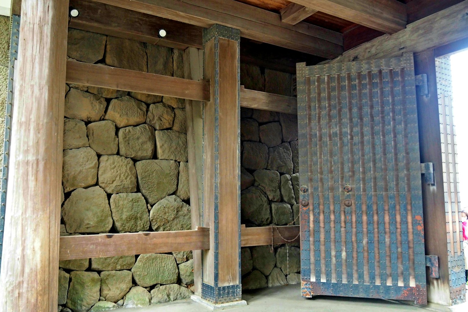 Interior of a traditional building featuring wooden beams and stone wall