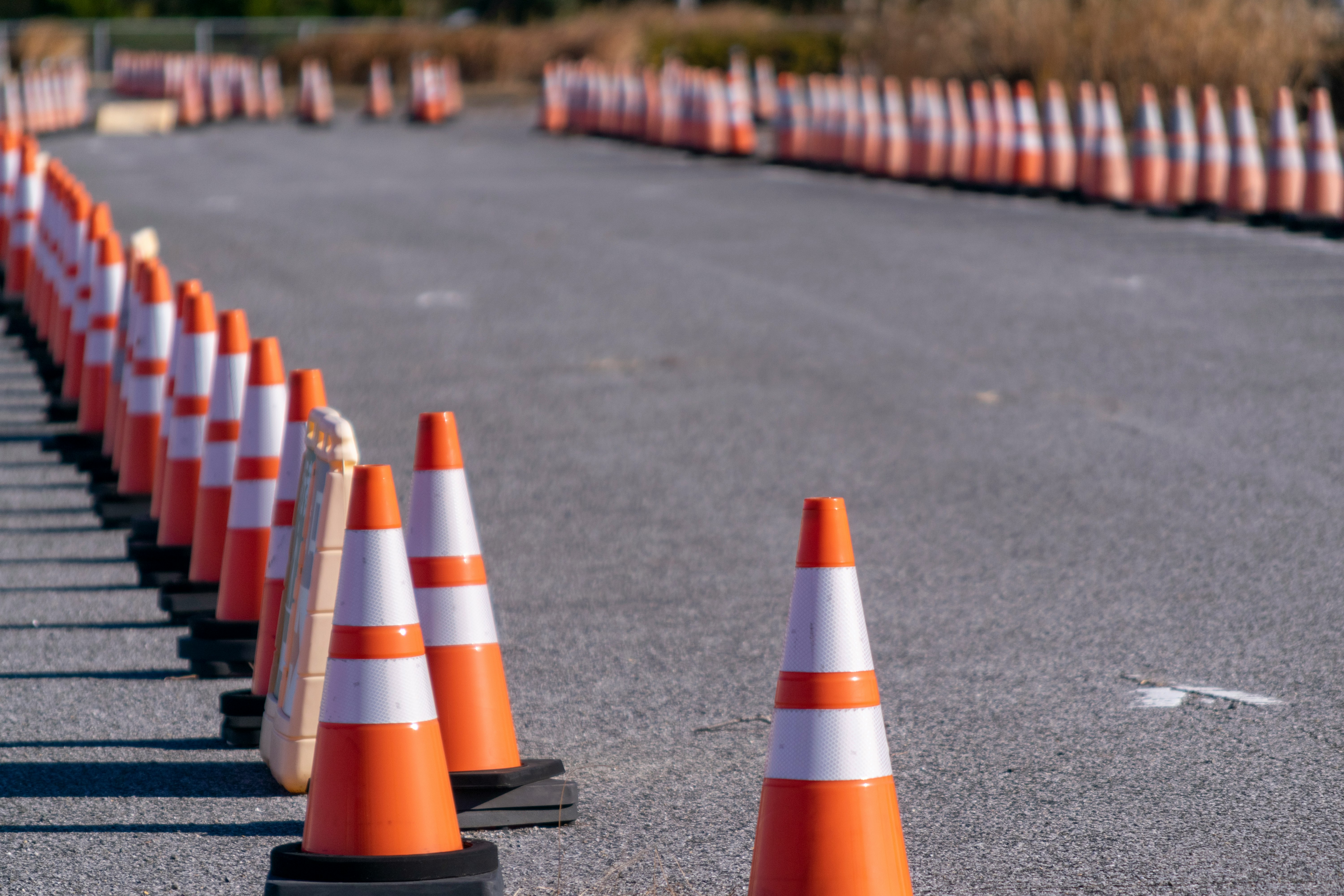 道路に並ぶオレンジのコーンと交通規制のバリケード