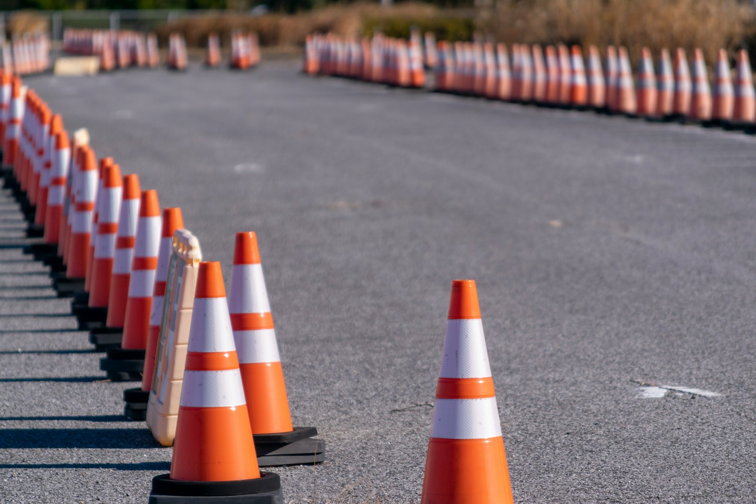 Reihe von orange-weißen Verkehrshütchen entlang einer Asphaltstraße