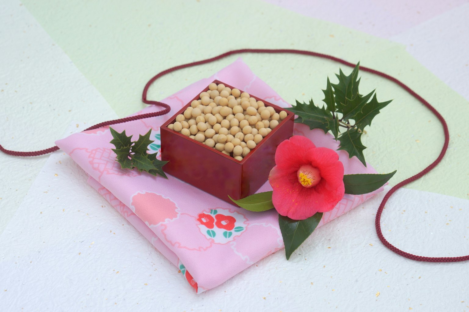 Wagashi bellamente dispuesto con un dulce cuadrado rojo cubierto de frijoles y rodeado de flores