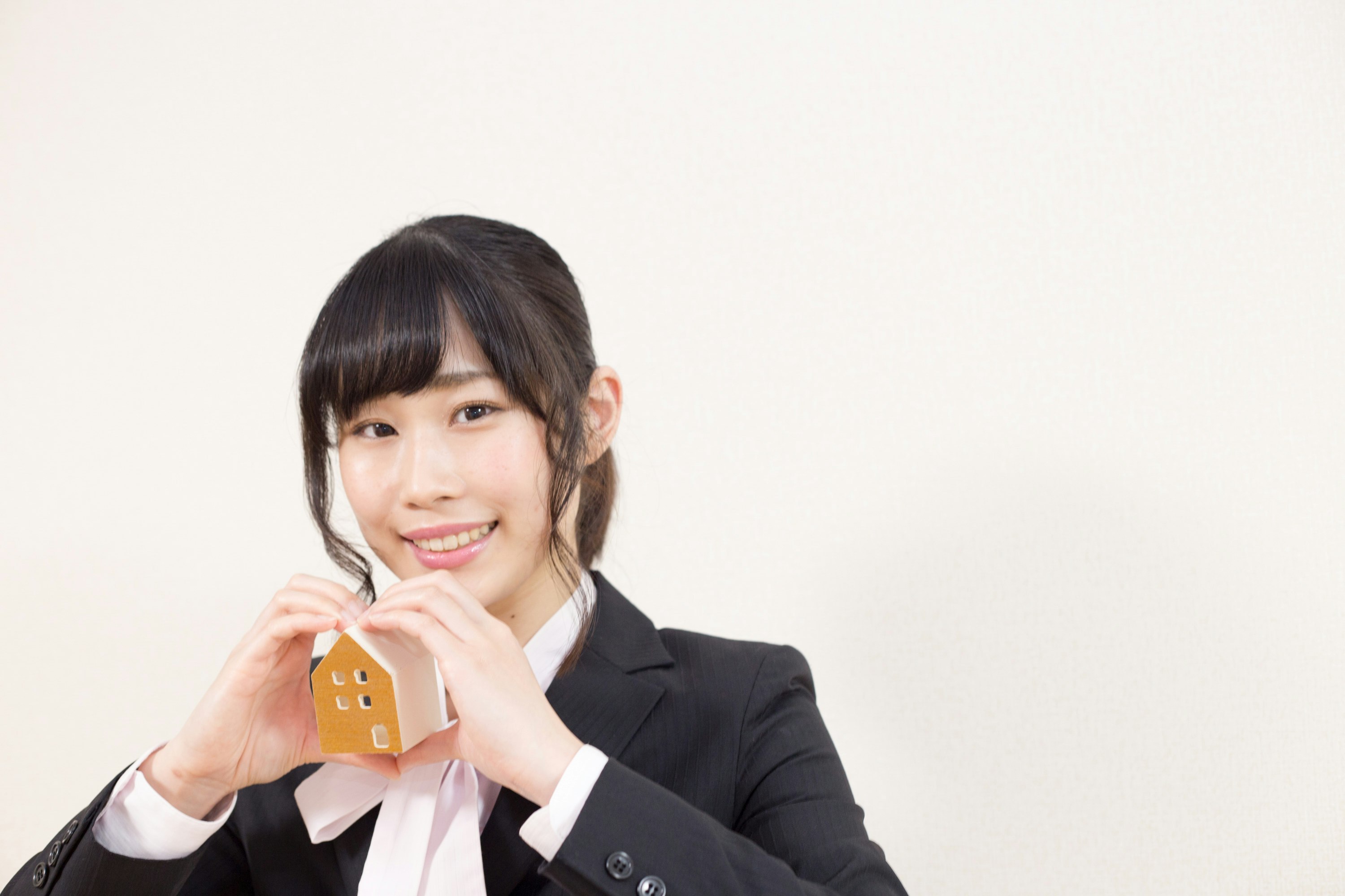 Woman in a suit holding a business card against a white background