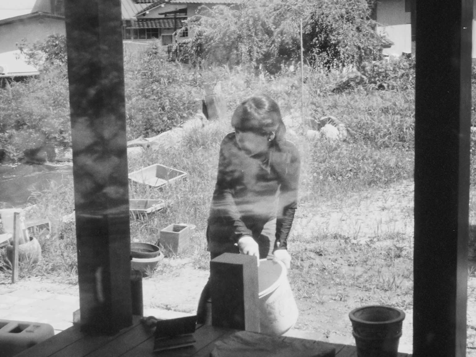 Black and white photo of a woman working in the garden