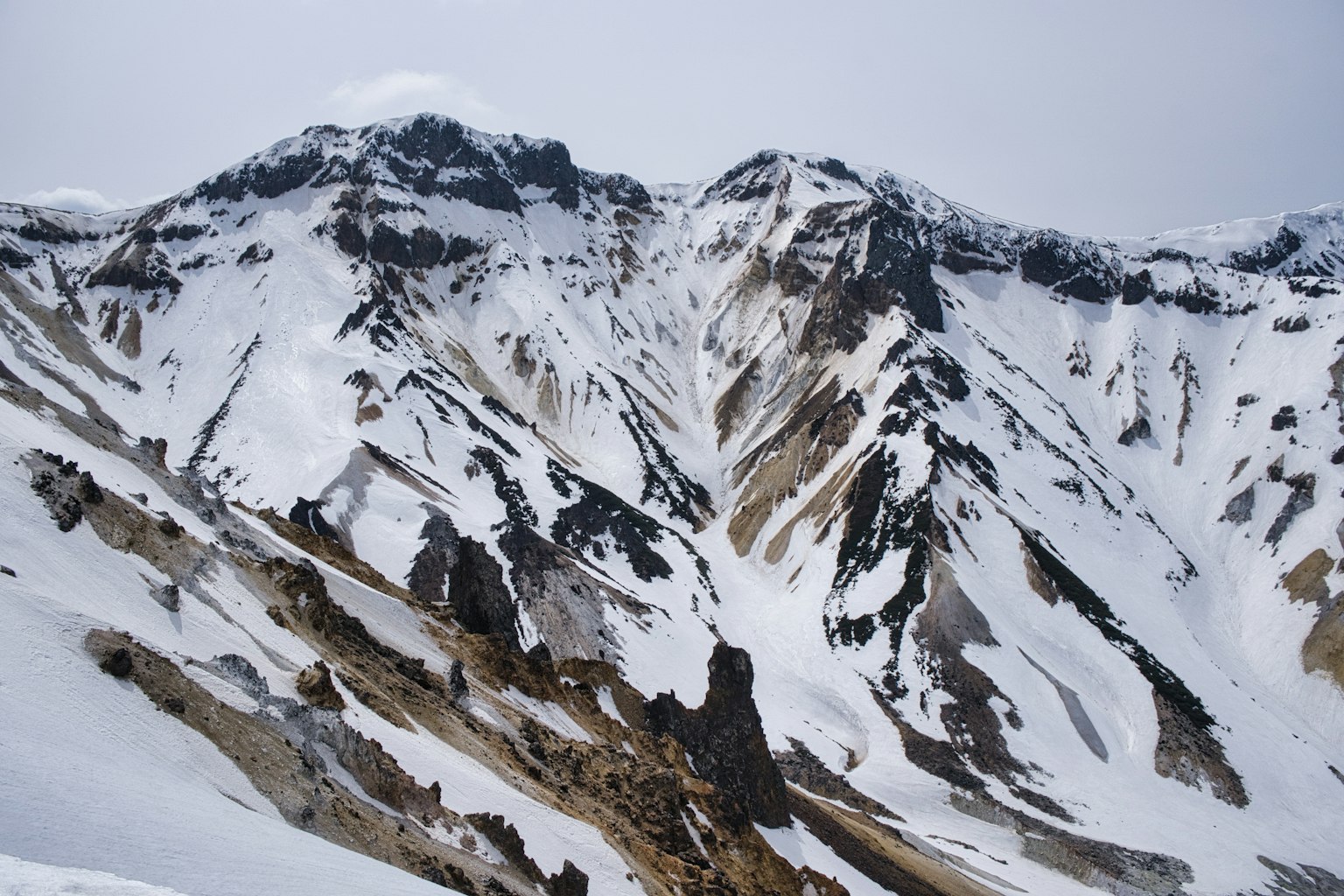 Snow-covered mountains with exposed rock formations
