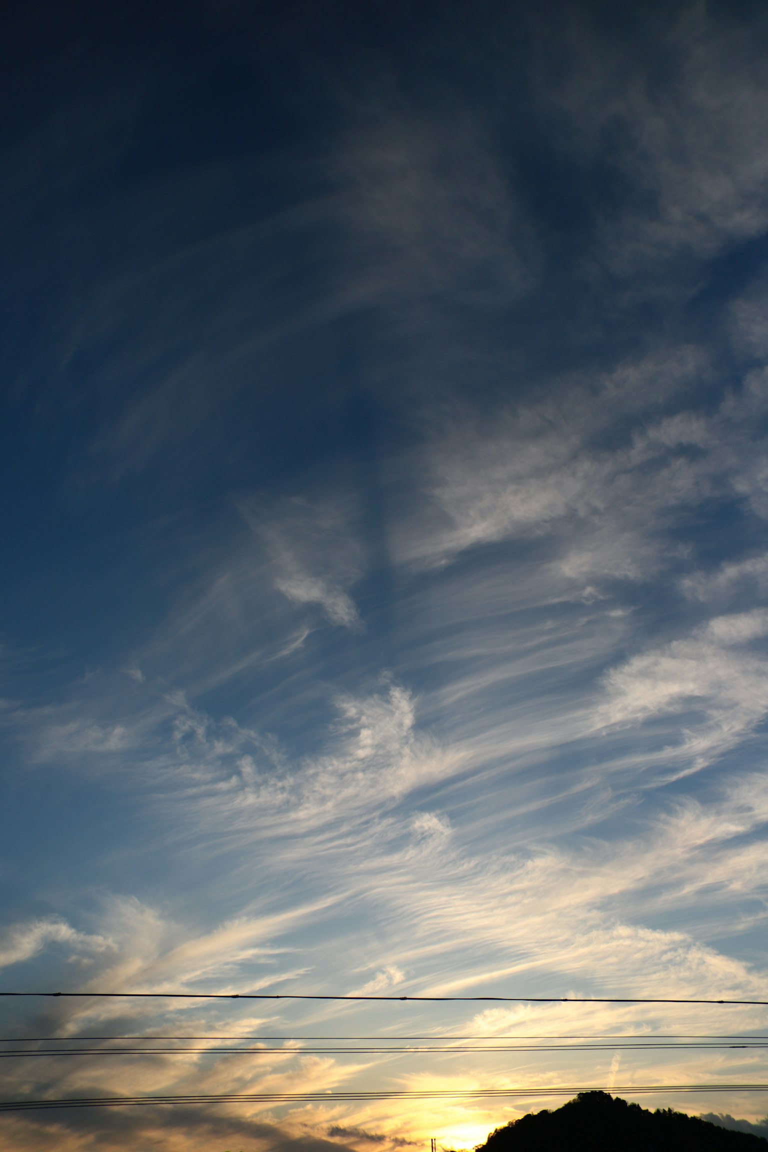 Nubes flotantes en un cielo azul crepuscular con luz cálida