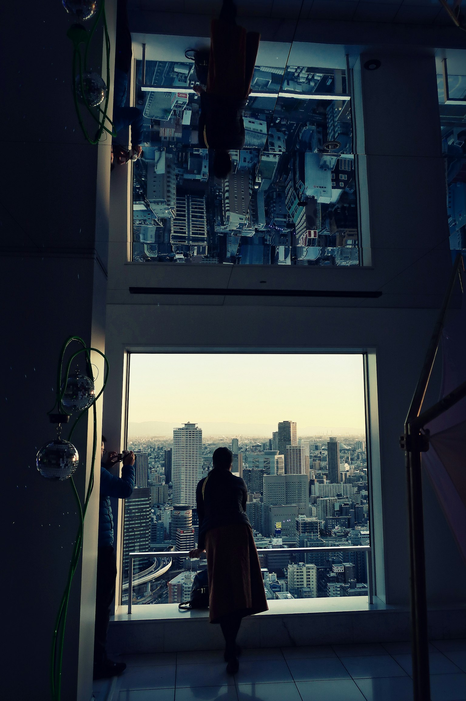 Bóng dáng của một người phụ nữ nhìn ra cảnh quan thành phố Các tòa nhà cao tầng nhìn thấy qua cửa sổ