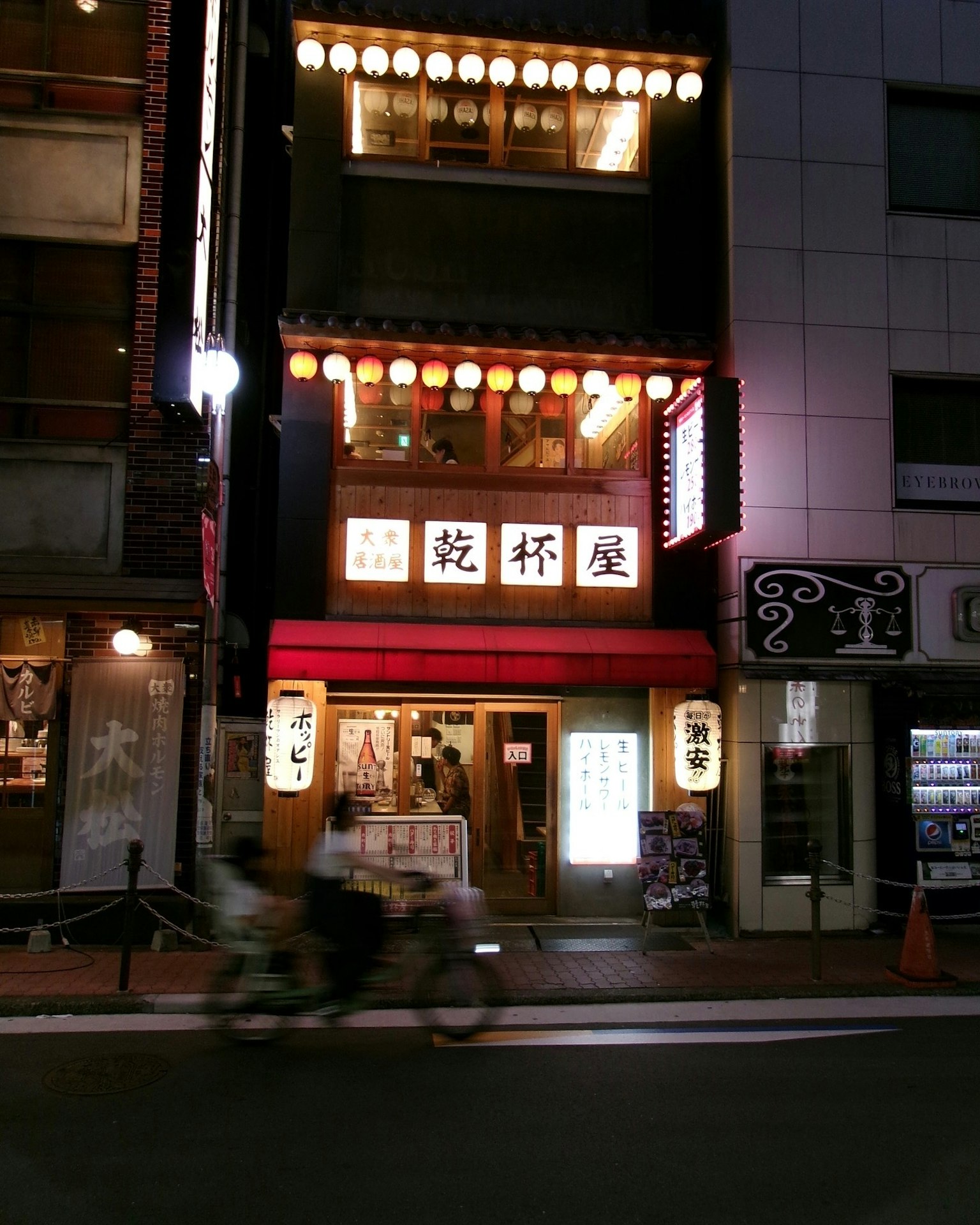 Traditional Japanese izakaya exterior glowing at night