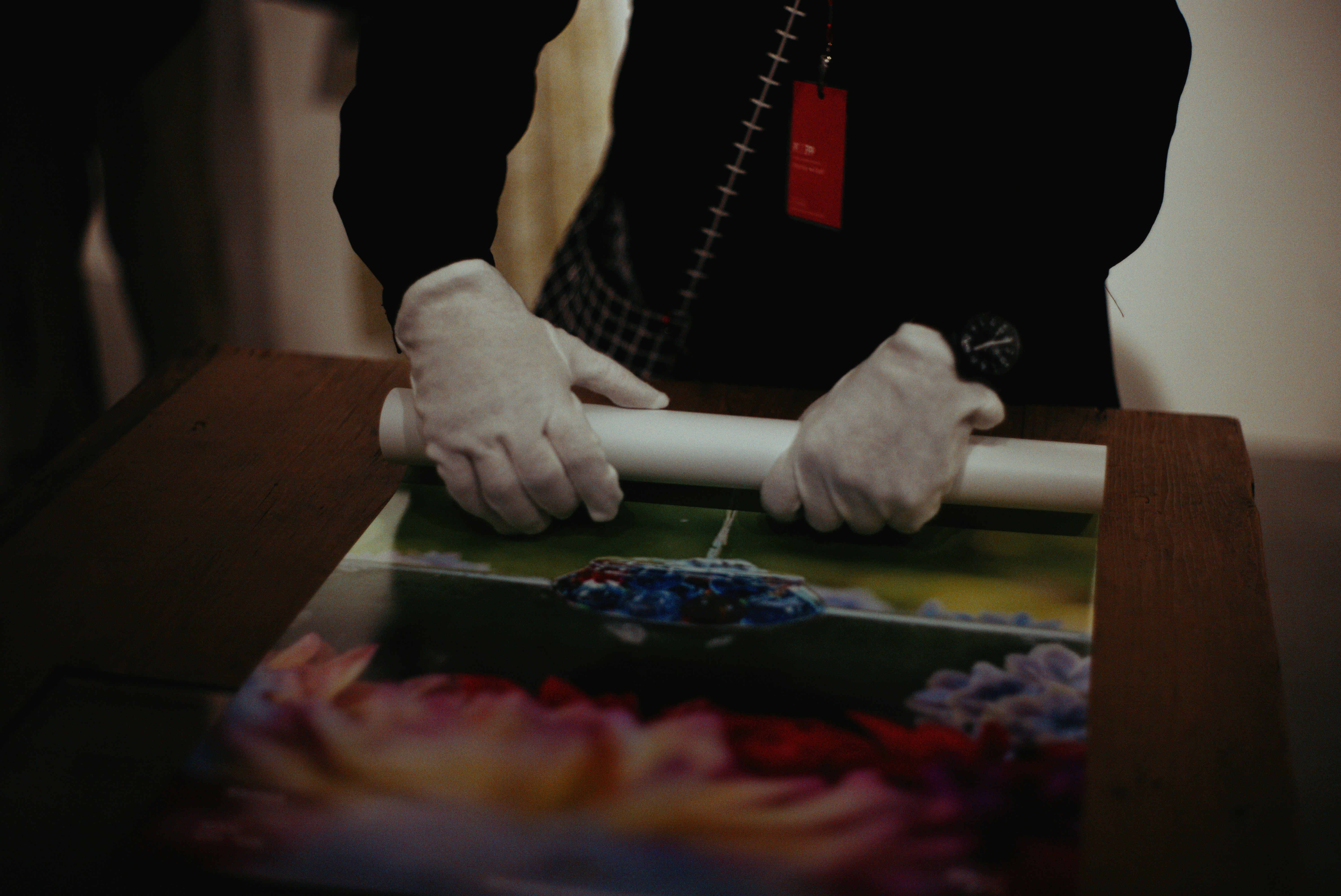มือช่างกำลังทำงานกับงานศิลปะที่ใส่กรอบ