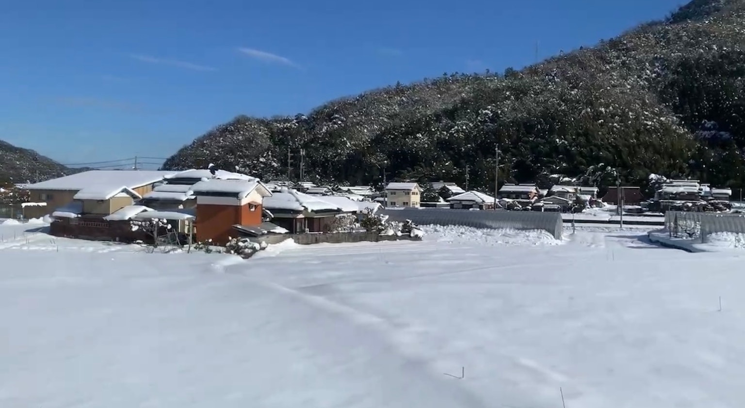 被雪覆蓋的村莊風景 藍天和背景中的山脈