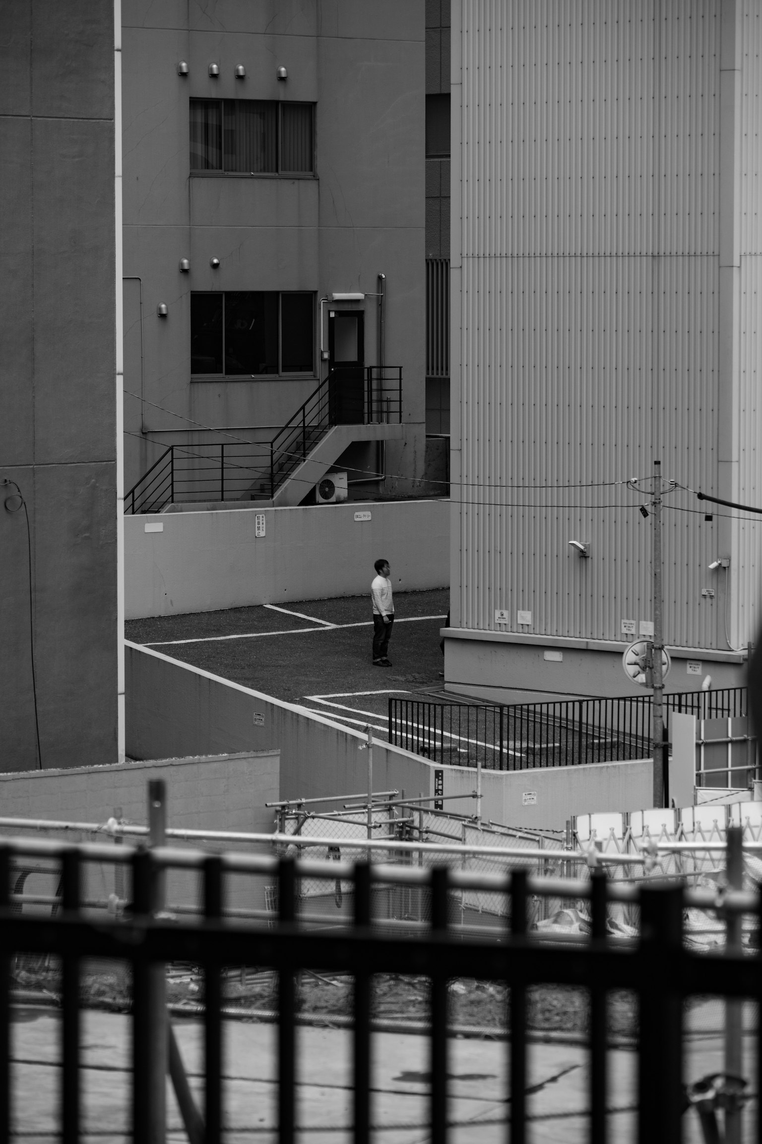 A monochrome urban scene featuring a person standing
