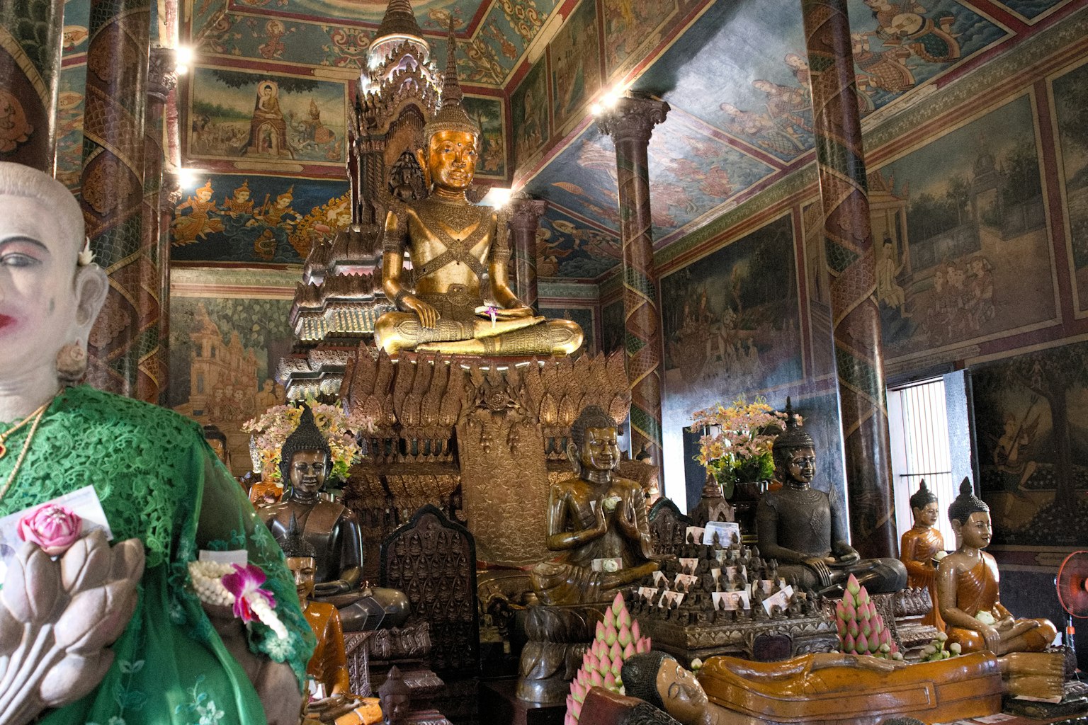 Interior de un templo con una gran estatua de Buda y decoraciones intrincadas