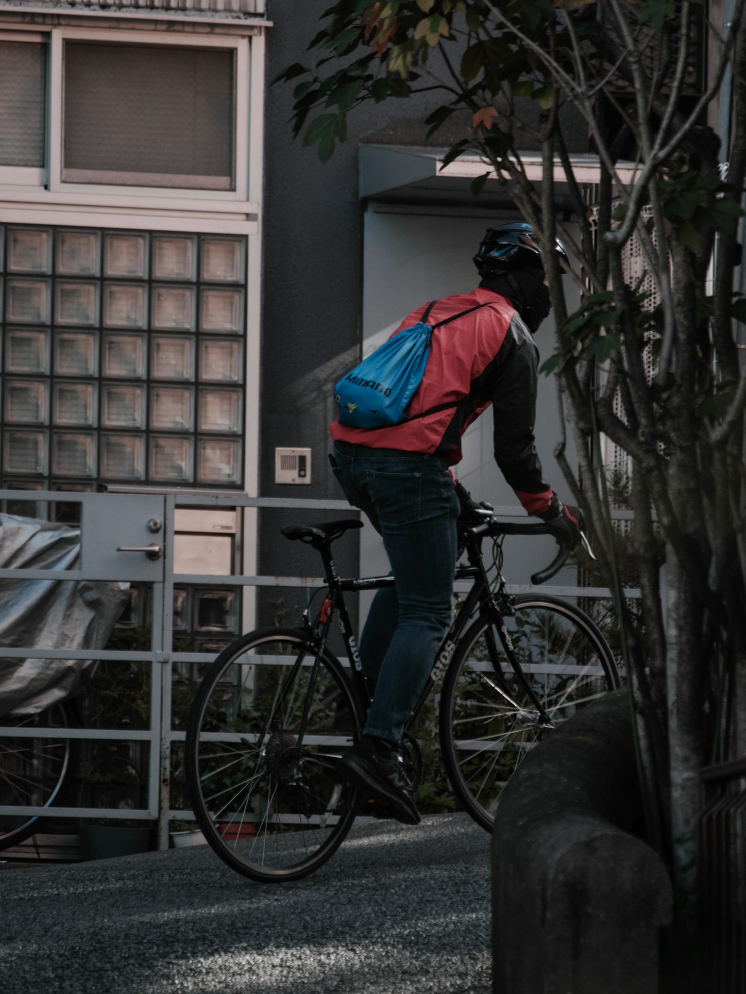 Person riding a bicycle wearing a backpack in an urban setting