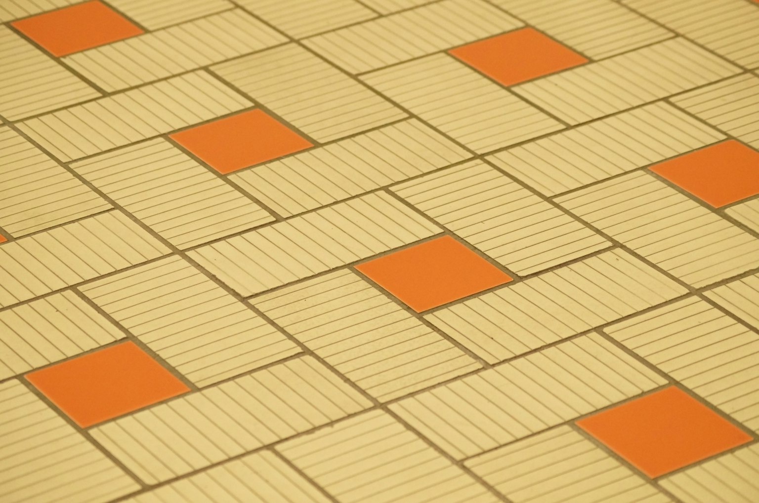 Design de sol avec des carrés orange alternés et des carreaux rayés