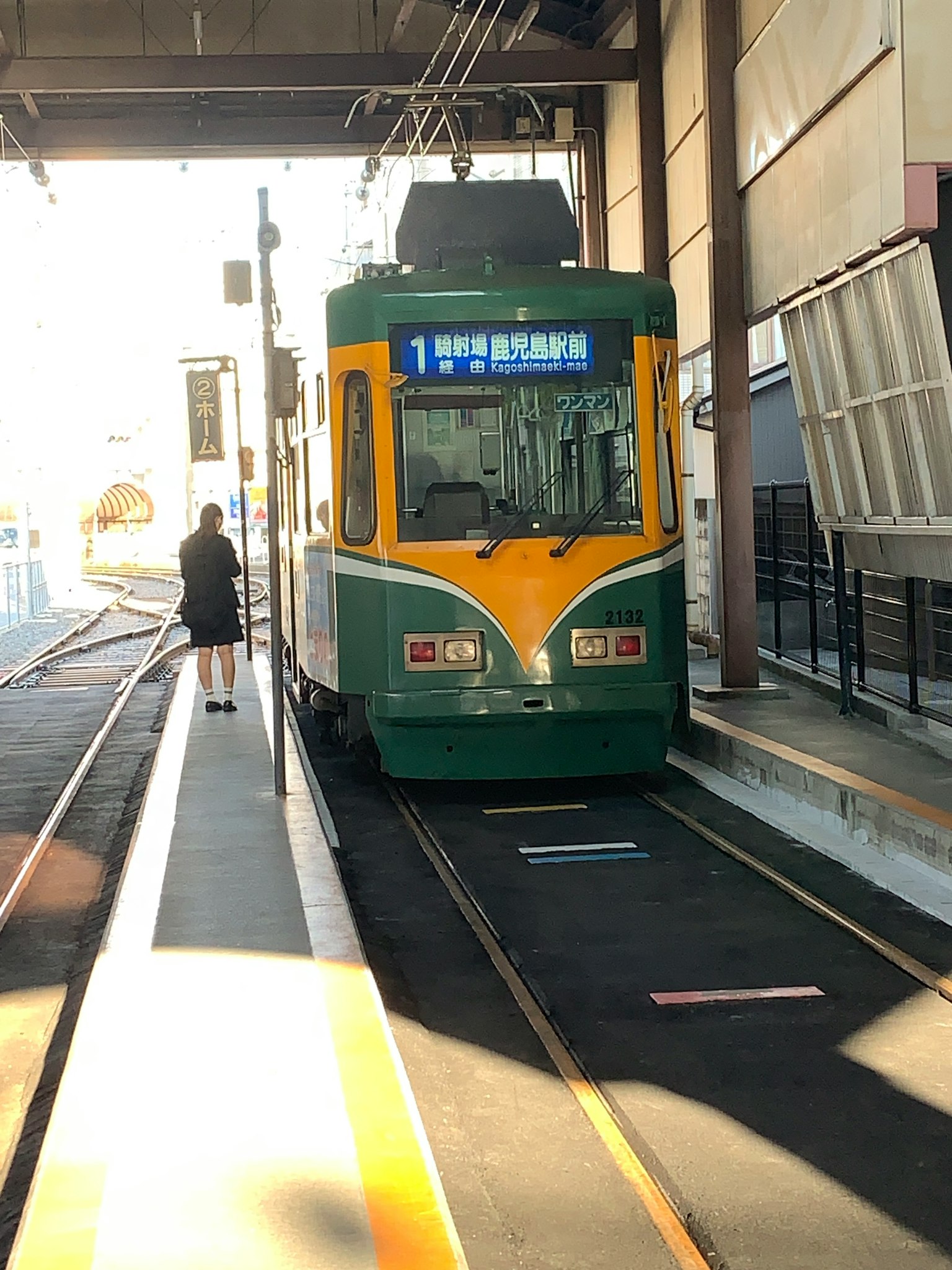 Tramway vert et jaune arrêté à la station