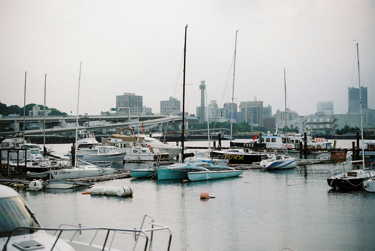 Bateaux amarrés dans un port avec une skyline urbaine en arrière-plan