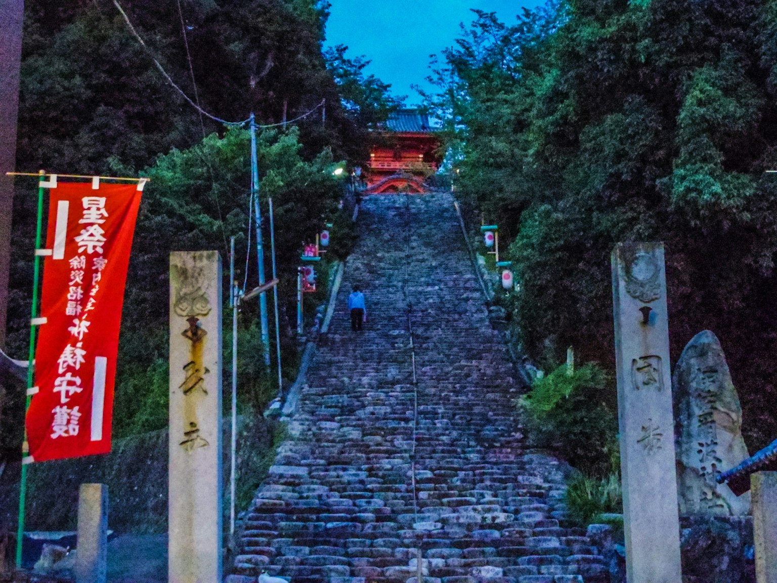 夜景中有石階和人們朝紅色鳥居走去